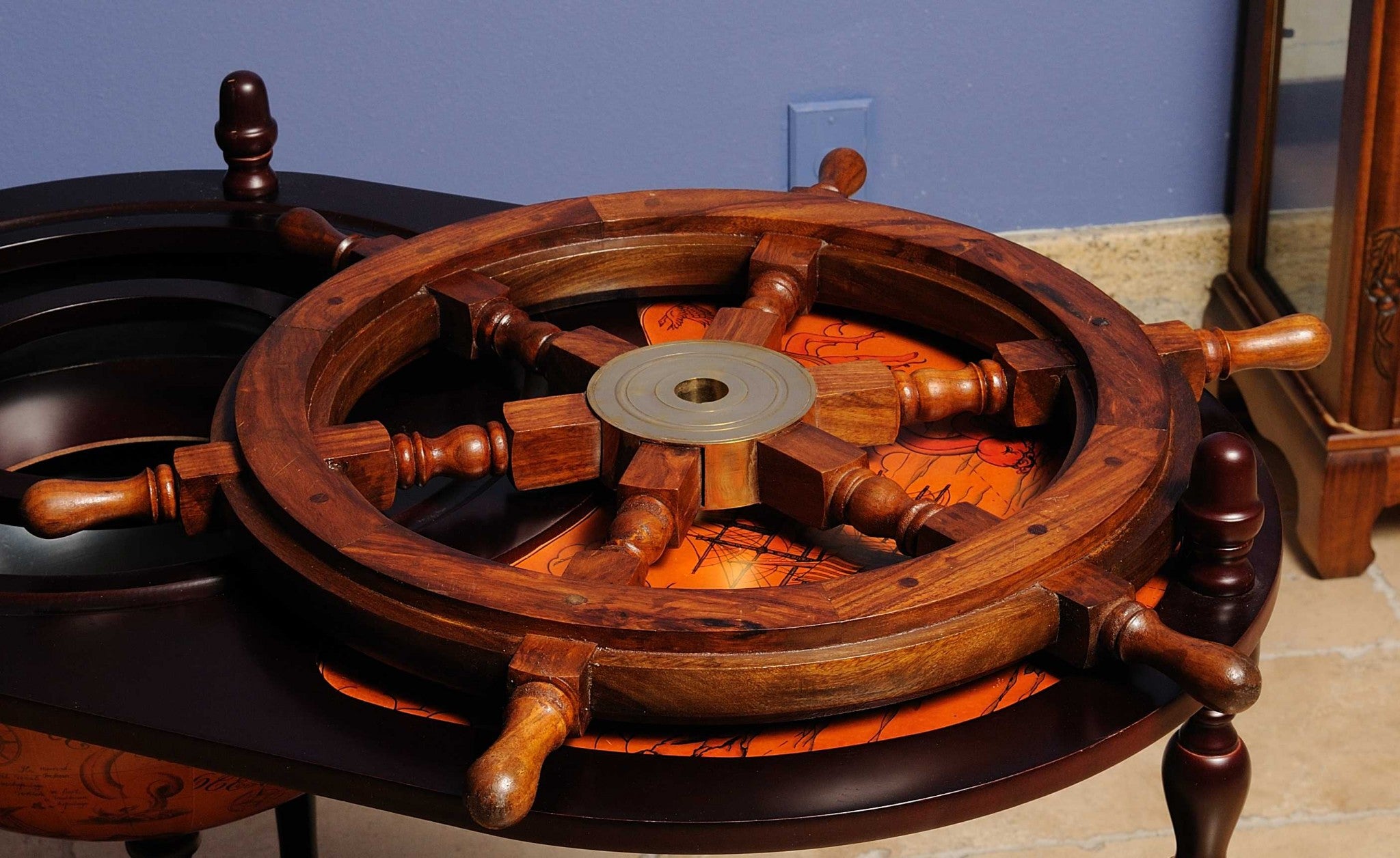A beautifully crafted 24-inch ship wheel made of rosewood with a golden brass hub, showcasing a classic nautical design.