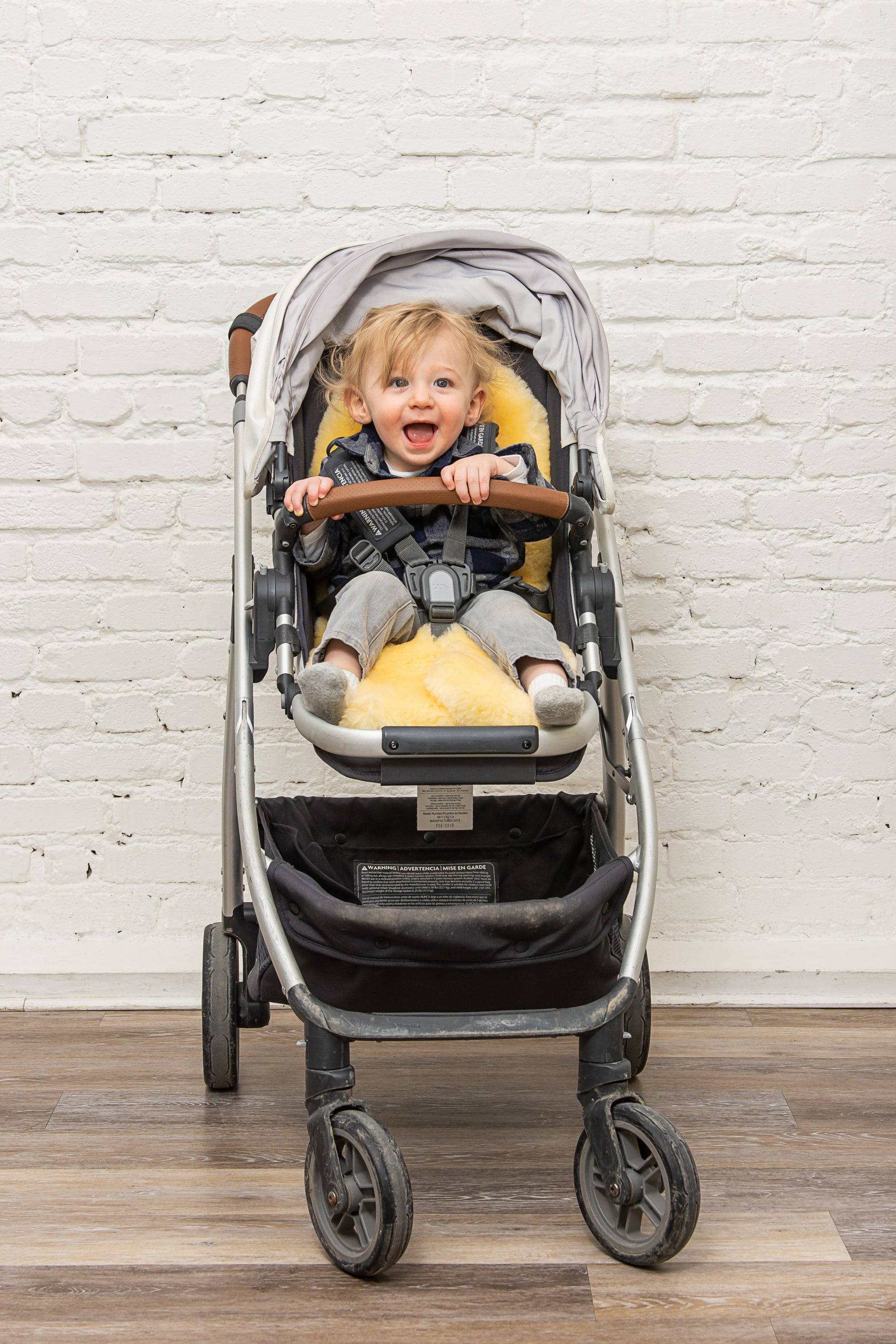 Cream cozy baby medium lambskin play rug measuring 24x36 inches, showcasing its soft texture and luxurious design.