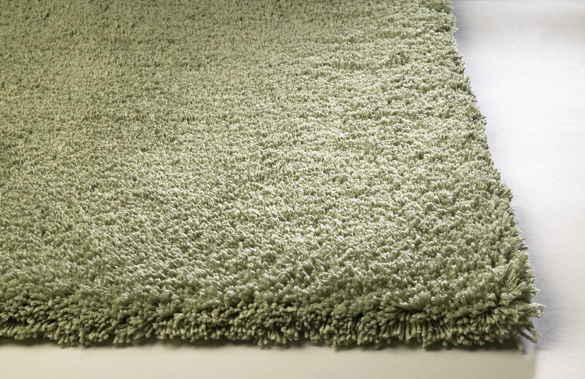 A beautiful sage green indoor shag rug measuring 2x4 feet, showcasing a soft texture and contemporary design, perfect for enhancing home decor.