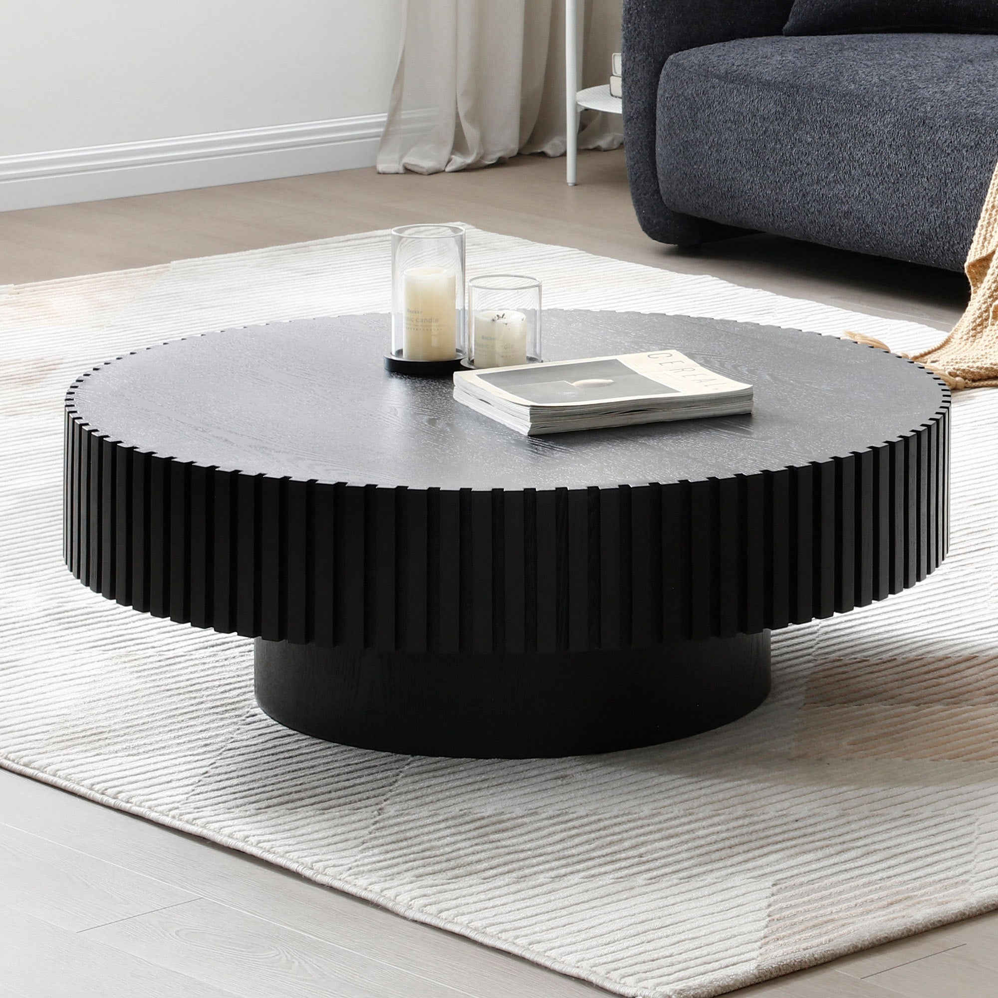 A modern 31.49'' nesting round wood coffee table in matt black, showcasing its sleek design and sturdy pedestal base, perfect for small living spaces.