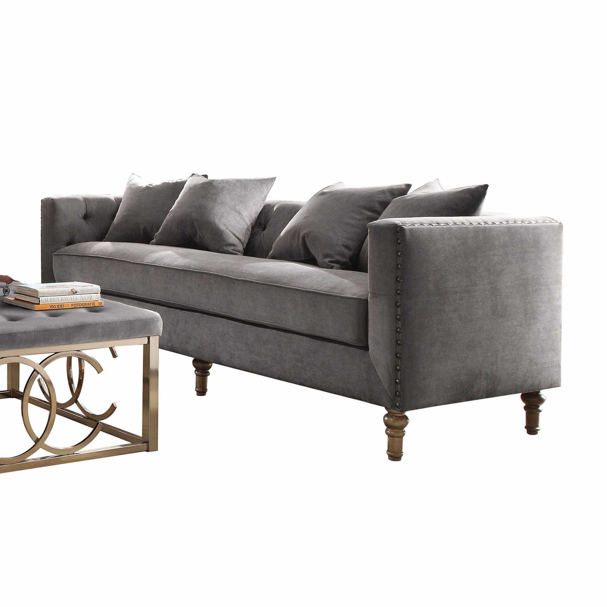 Gray velvet upholstery sofa with tufted back and 4 pillows, showcasing mid-century modern design and elegant nailhead trim.