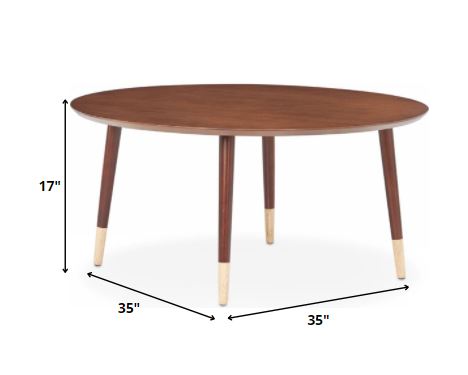 Walnut mid-century modern coffee table with round top and tapered legs, showcasing intricate design and rich wood finish.