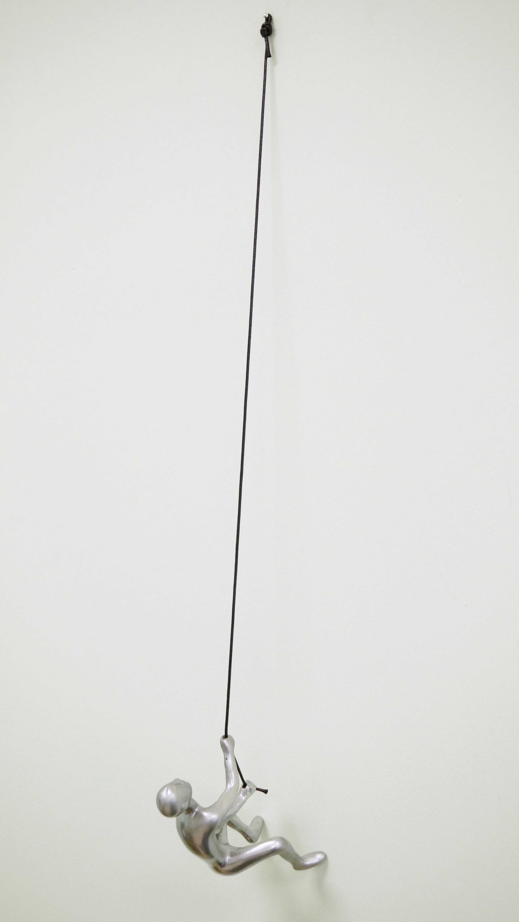 Silver climbing man wall art sculpture, elegantly designed with a twisted rope for hanging, perfect for modern decor.