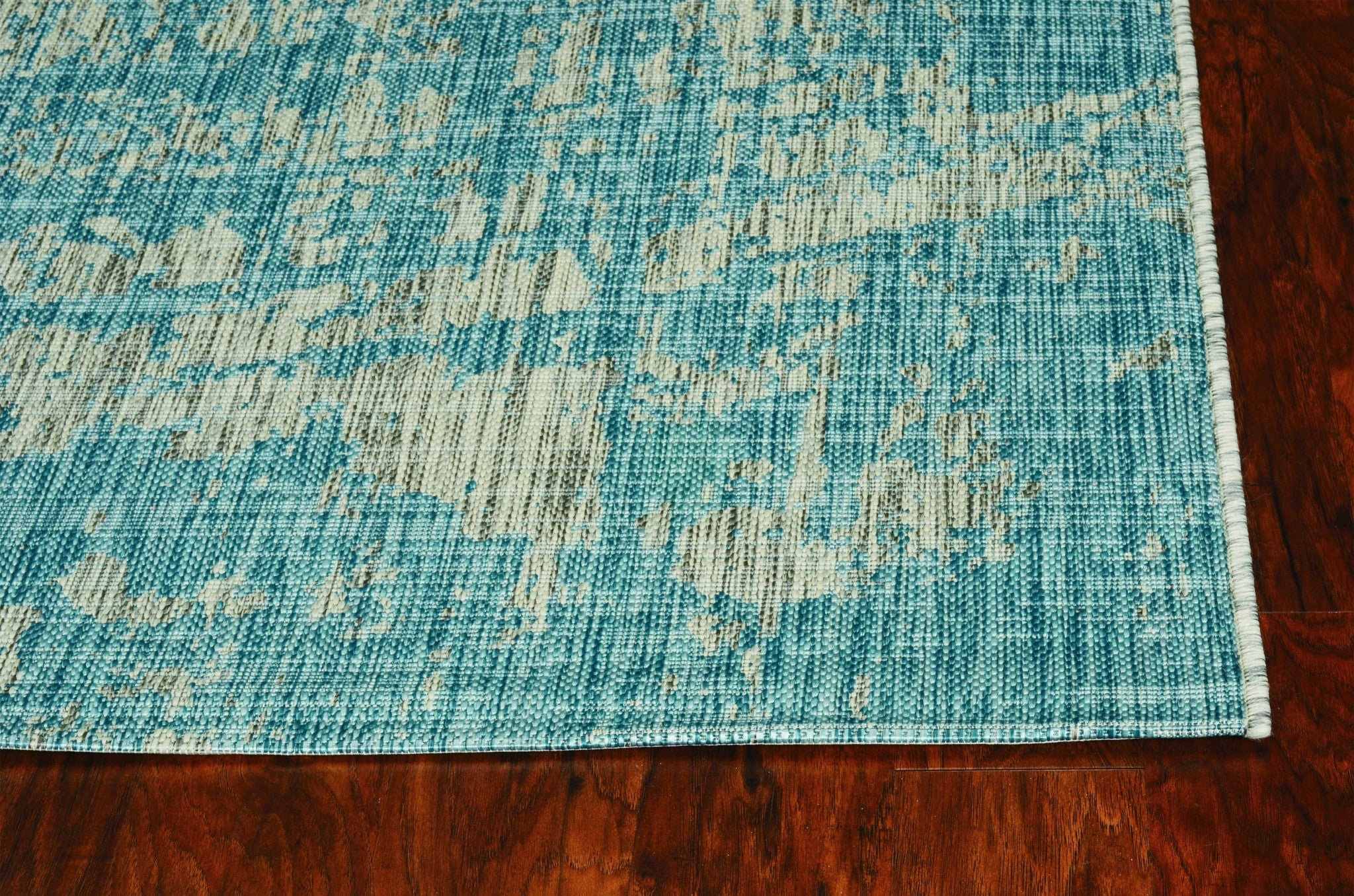 A vibrant teal polypropylene area rug measuring 3x4 inches, showcasing a contemporary design suitable for indoor and outdoor use.