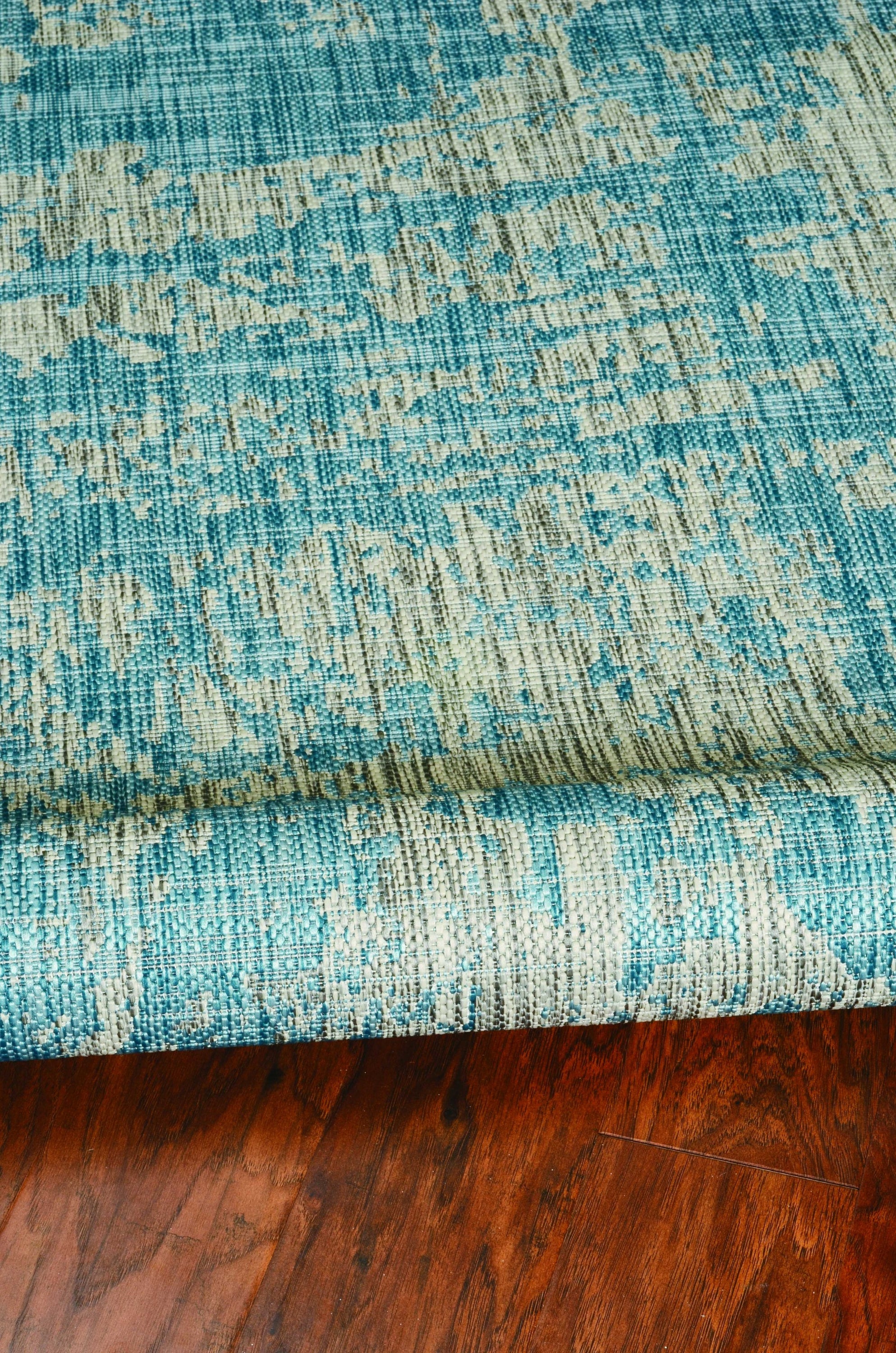 A vibrant teal polypropylene area rug measuring 3x4 inches, showcasing a contemporary design suitable for indoor and outdoor use.
