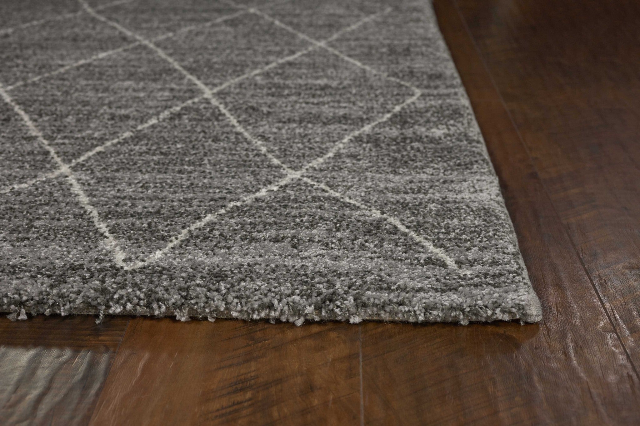 A plush grey area rug featuring a diamond pattern, perfect for modern home decor.