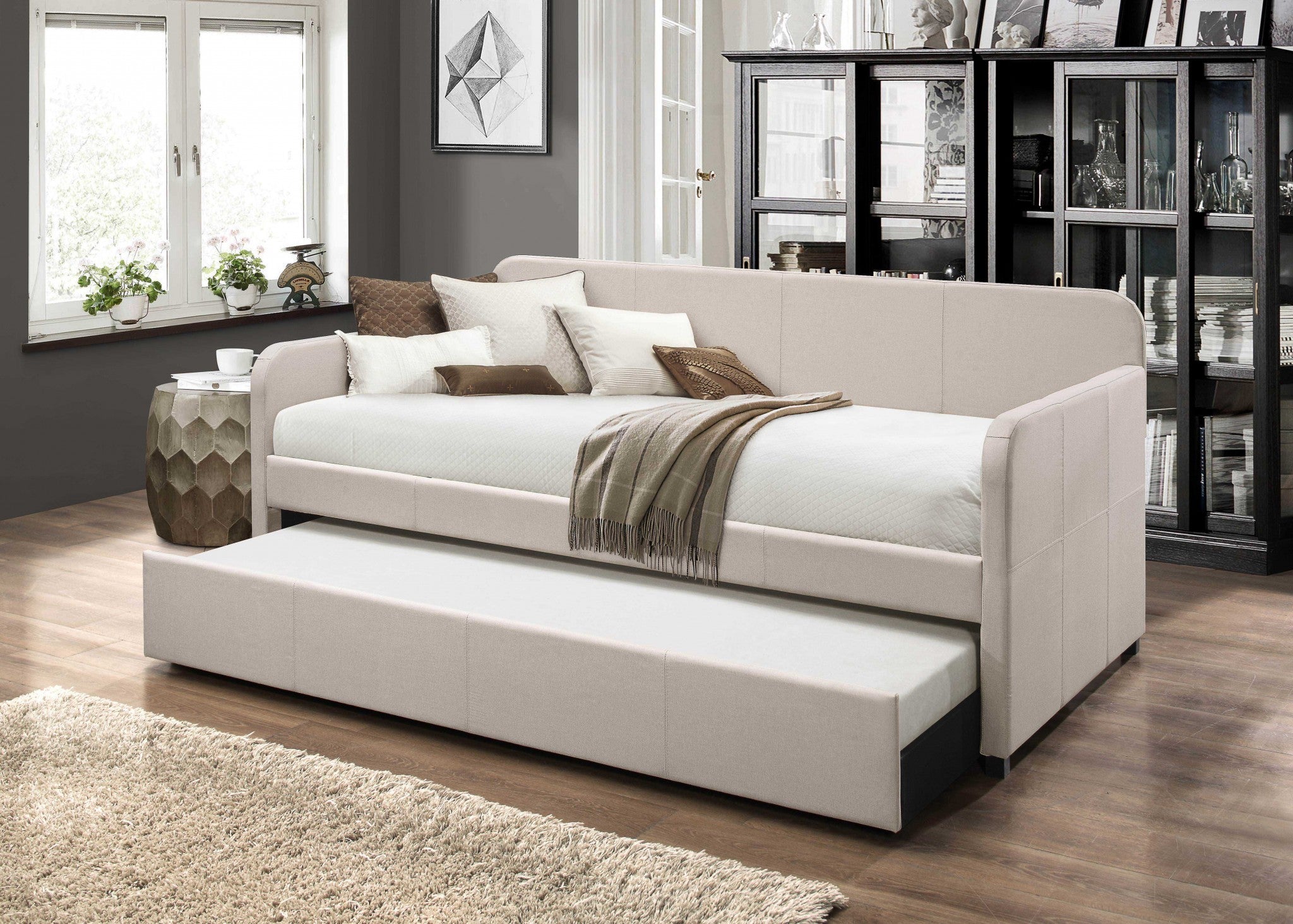 A stylish 43x82 inches fabric upholstered daybed with wood legs, featuring a beige upholstery and a convenient tuck-away trundle bed.