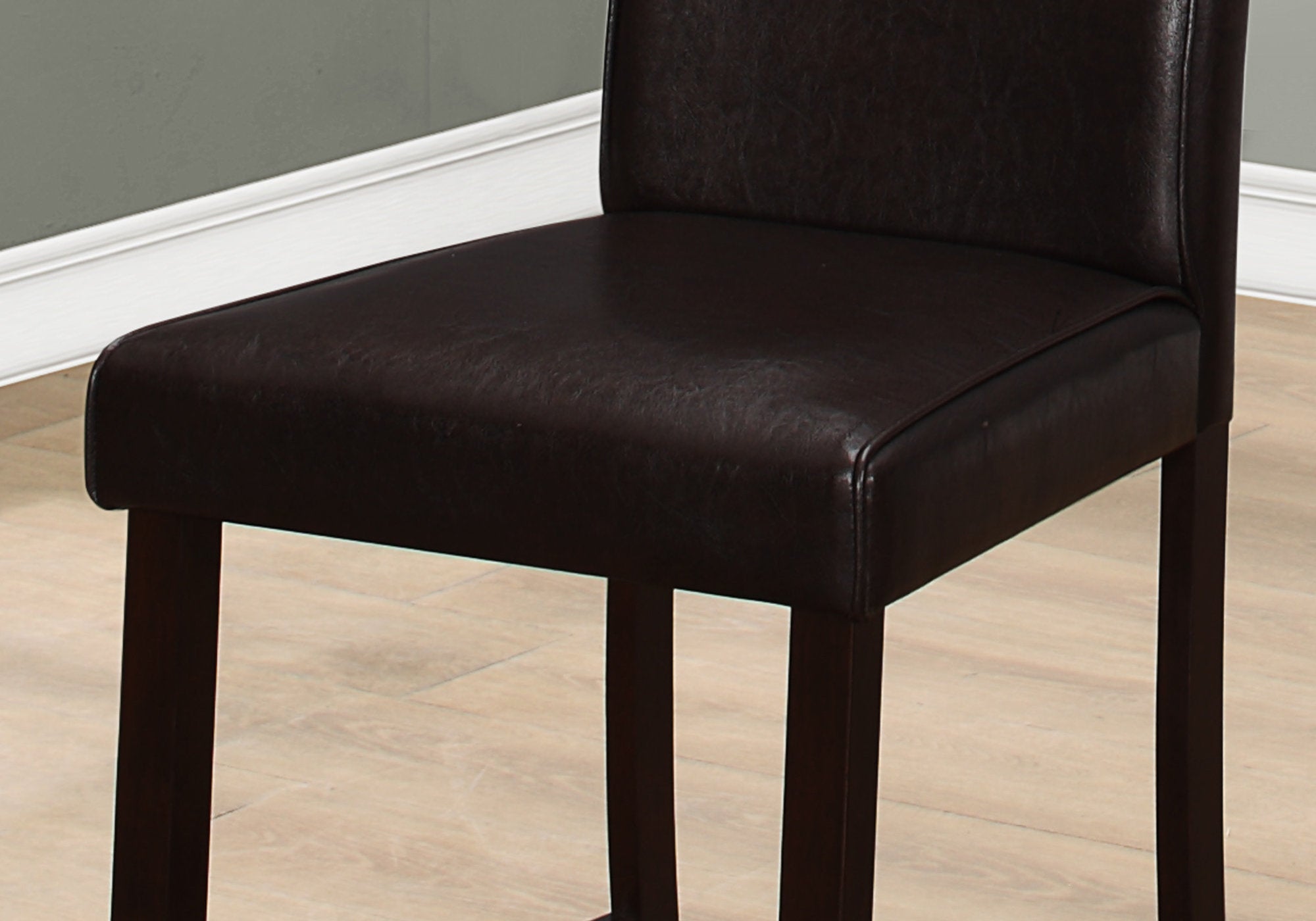 Set of two brown leather look counter height dining chairs, showcasing elegant design and sturdy construction, perfect for dining rooms.