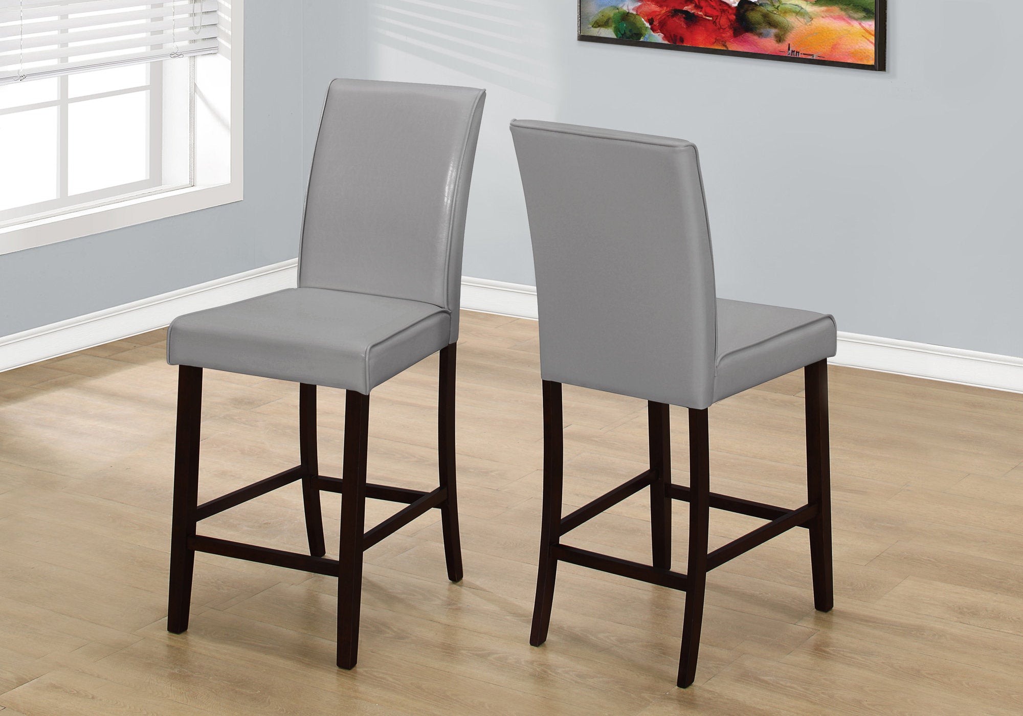 Set of two brown leather look counter height dining chairs, showcasing elegant design and sturdy construction, perfect for dining rooms.