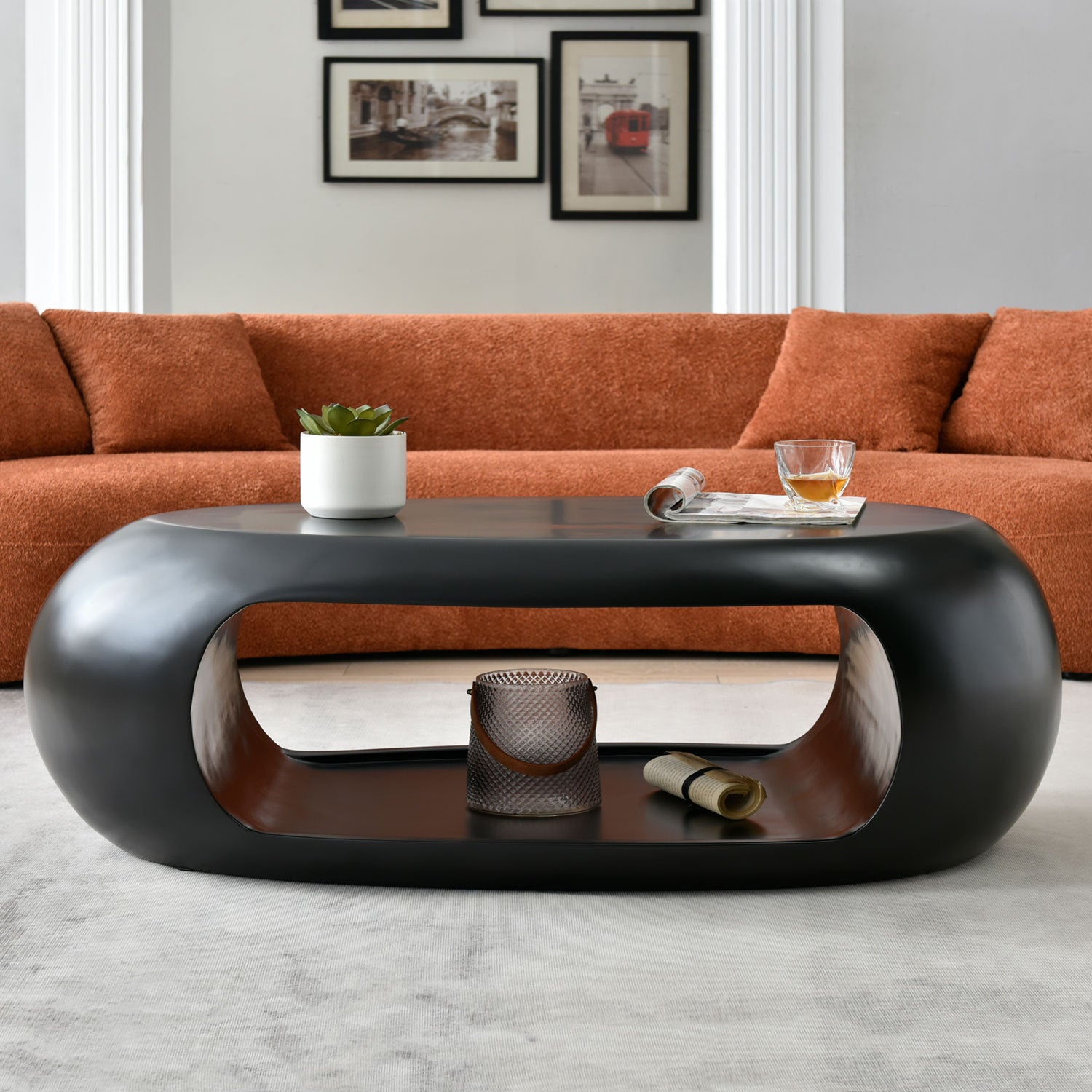 A modern oval coffee table made of sturdy fiberglass, featuring a sleek black finish, perfect for contemporary living spaces.