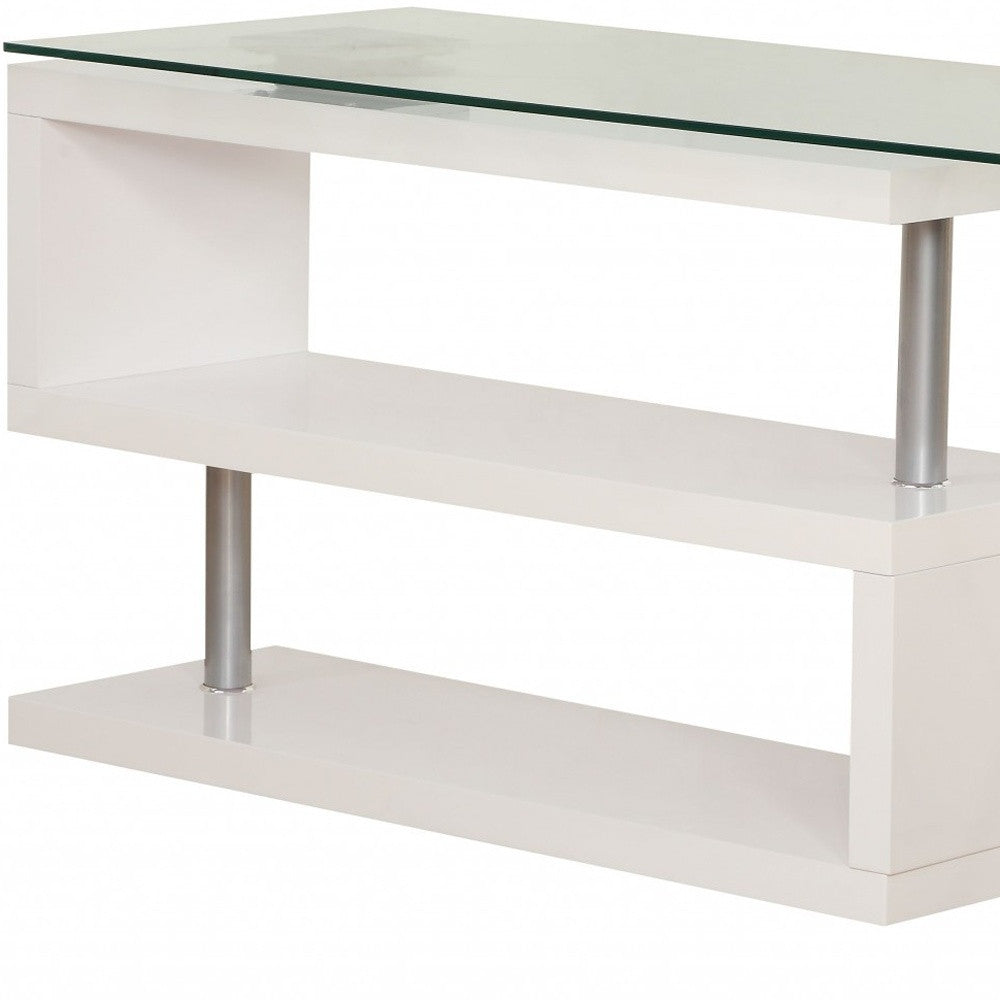 A modern black high gloss clear glass office desk featuring an L-shape design with a clear glass top and X-shape metal legs.
