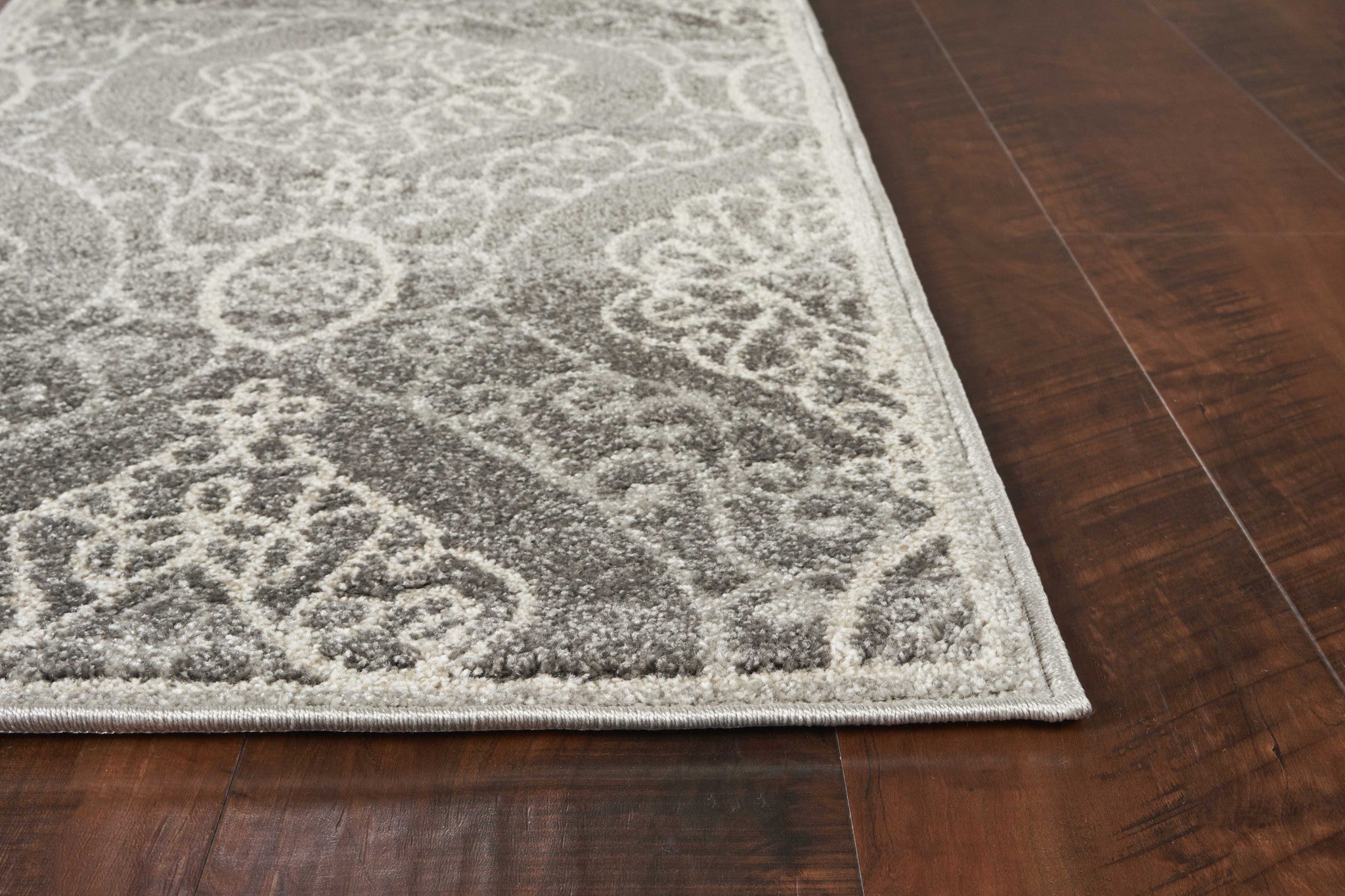 A beautiful silver machine woven rug featuring a floral ogee pattern, perfect for indoor and outdoor use, showcasing elegance and durability.