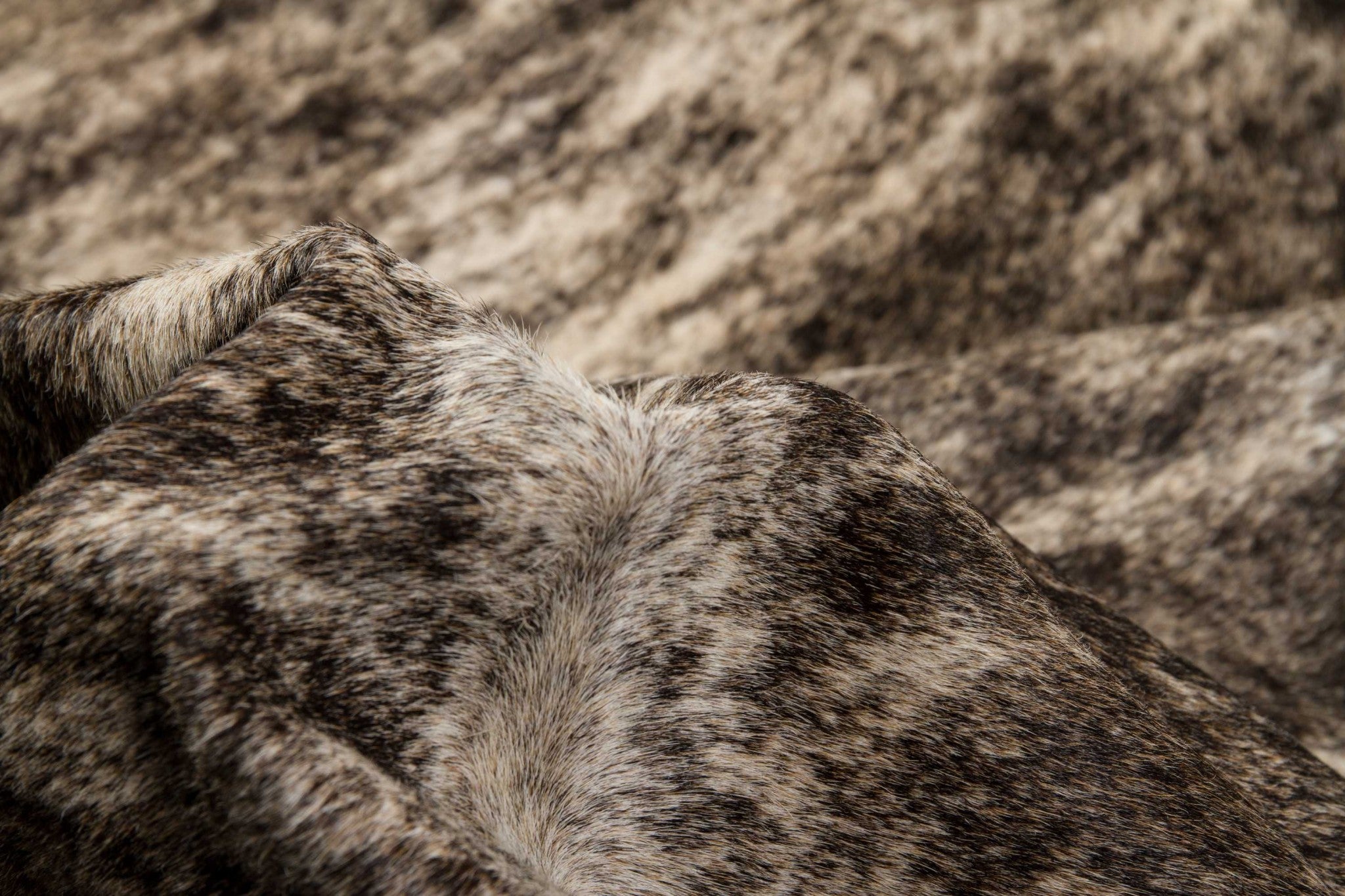 Handmade black and white cowhide area rug measuring 60x84 inches, showcasing a luxurious texture and unique patterns.