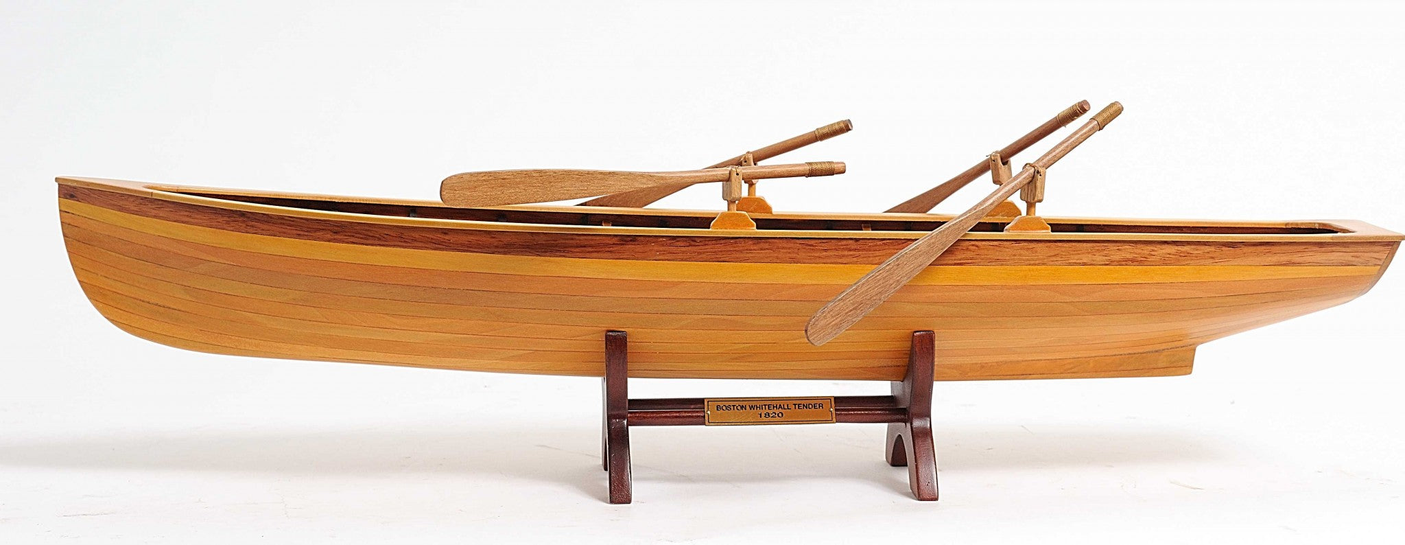 A beautifully crafted 6in x 24.5in x 6in wooden replica of a Boston Whitehall Tender rowing boat, showcasing intricate details and craftsmanship.
