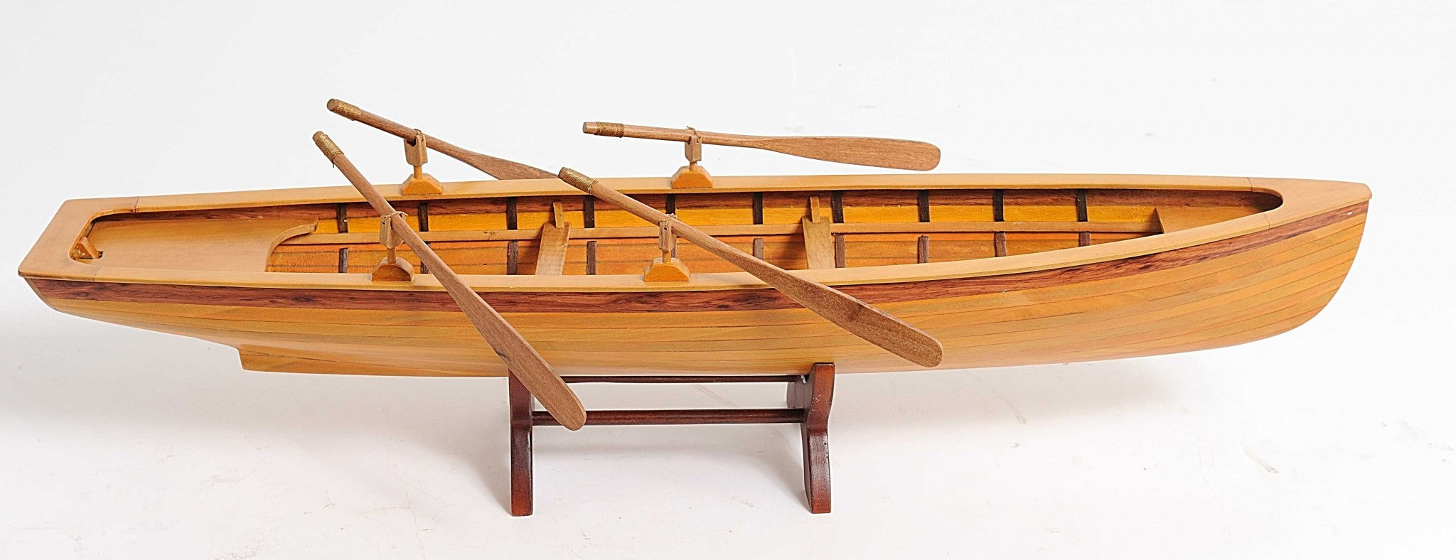 A beautifully crafted 6in x 24.5in x 6in wooden replica of a Boston Whitehall Tender rowing boat, showcasing intricate details and craftsmanship.