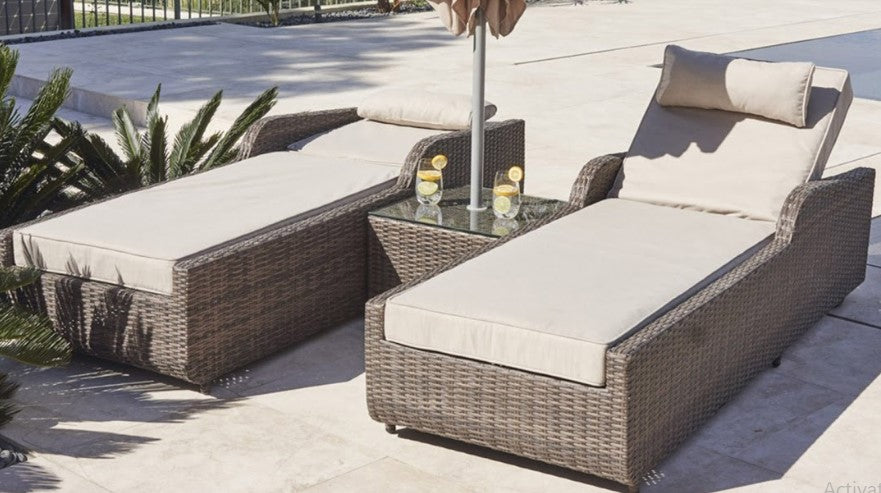Brown 3-Piece Outdoor Arm Chaise Lounge set featuring two lounges with cushions and a glass-top table, perfect for outdoor relaxation.