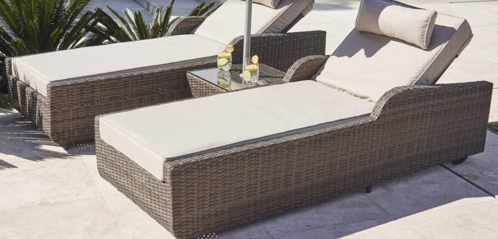 Brown 3-Piece Outdoor Arm Chaise Lounge set featuring two lounges with cushions and a glass-top table, perfect for outdoor relaxation.
