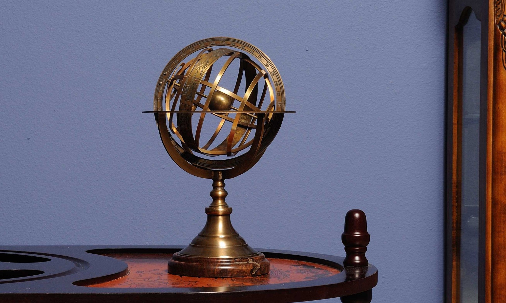 A beautifully crafted 7x7x11.5 inches brass armillary sphere on a wooden base, showcasing celestial rings and an Earth globe.