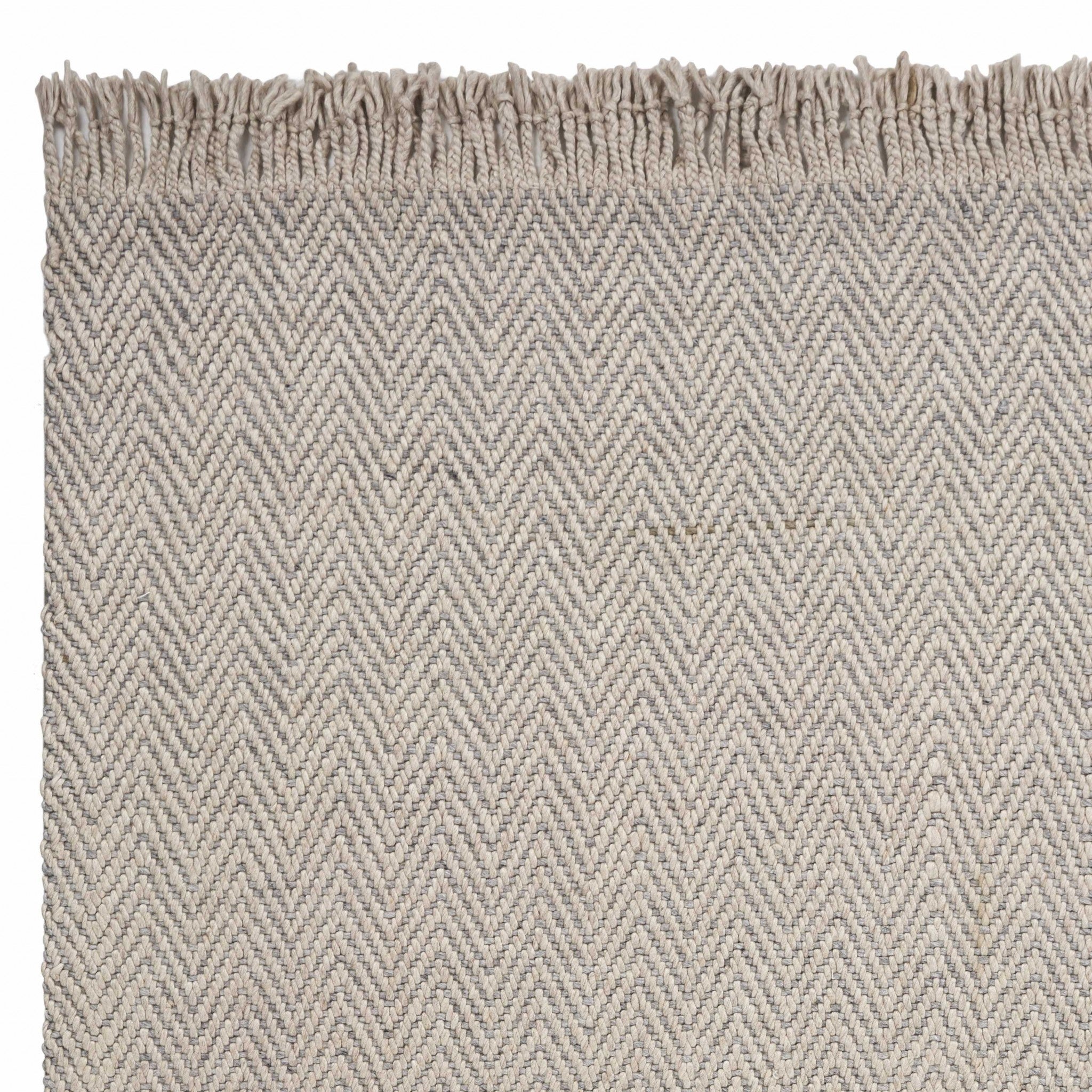 8 inches x 10 inches oatmeal beige hand woven herringbone indoor area rug with braided fringe, showcasing a modern design and high-quality wool material.