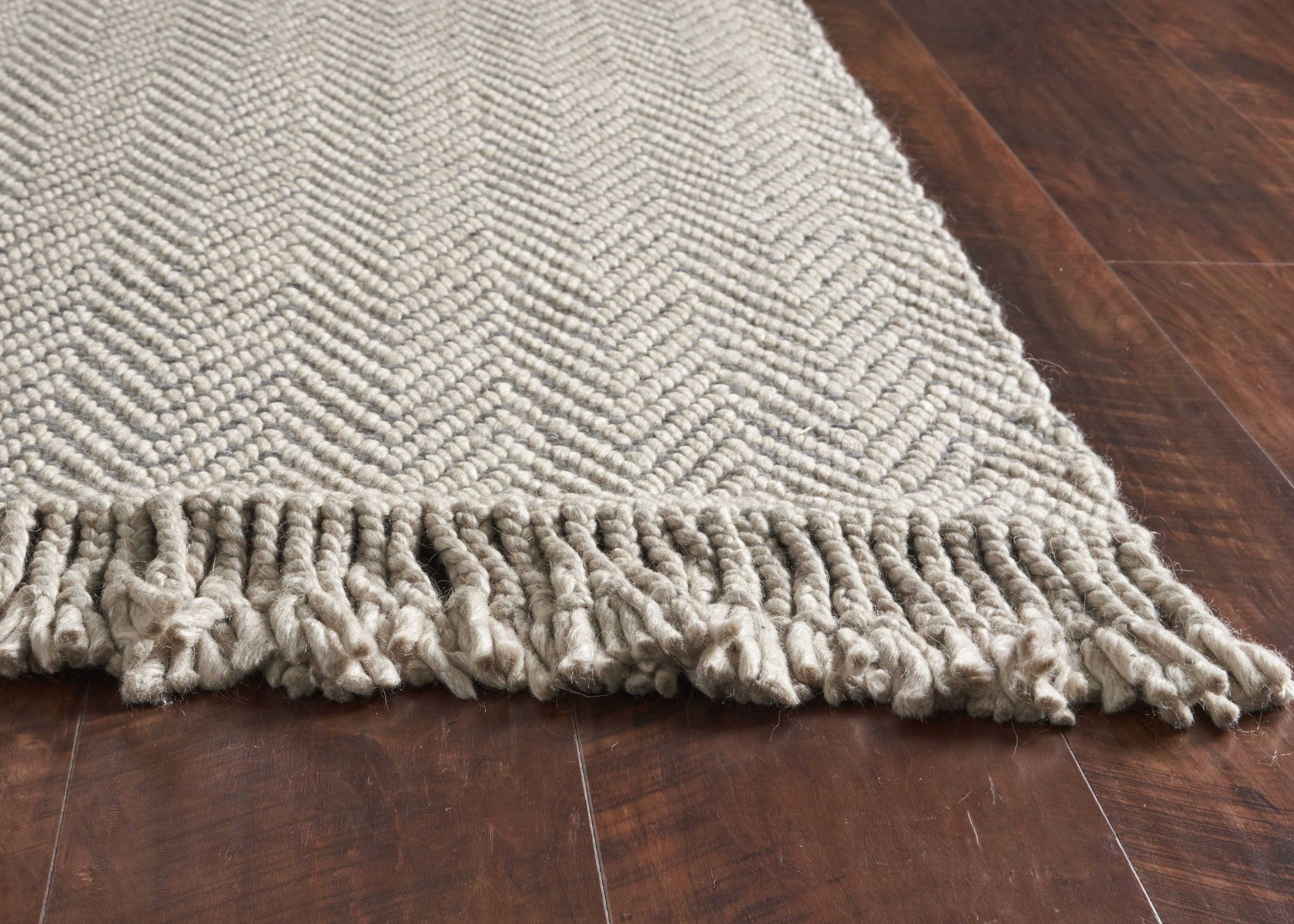 8 inches x 10 inches oatmeal beige hand woven herringbone indoor area rug with braided fringe, showcasing a modern design and high-quality wool material.