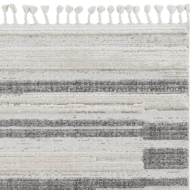 A stylish 94 x 130 ivory grey polyester rug with decorative cut loop pile and fringe, perfect for contemporary living spaces.