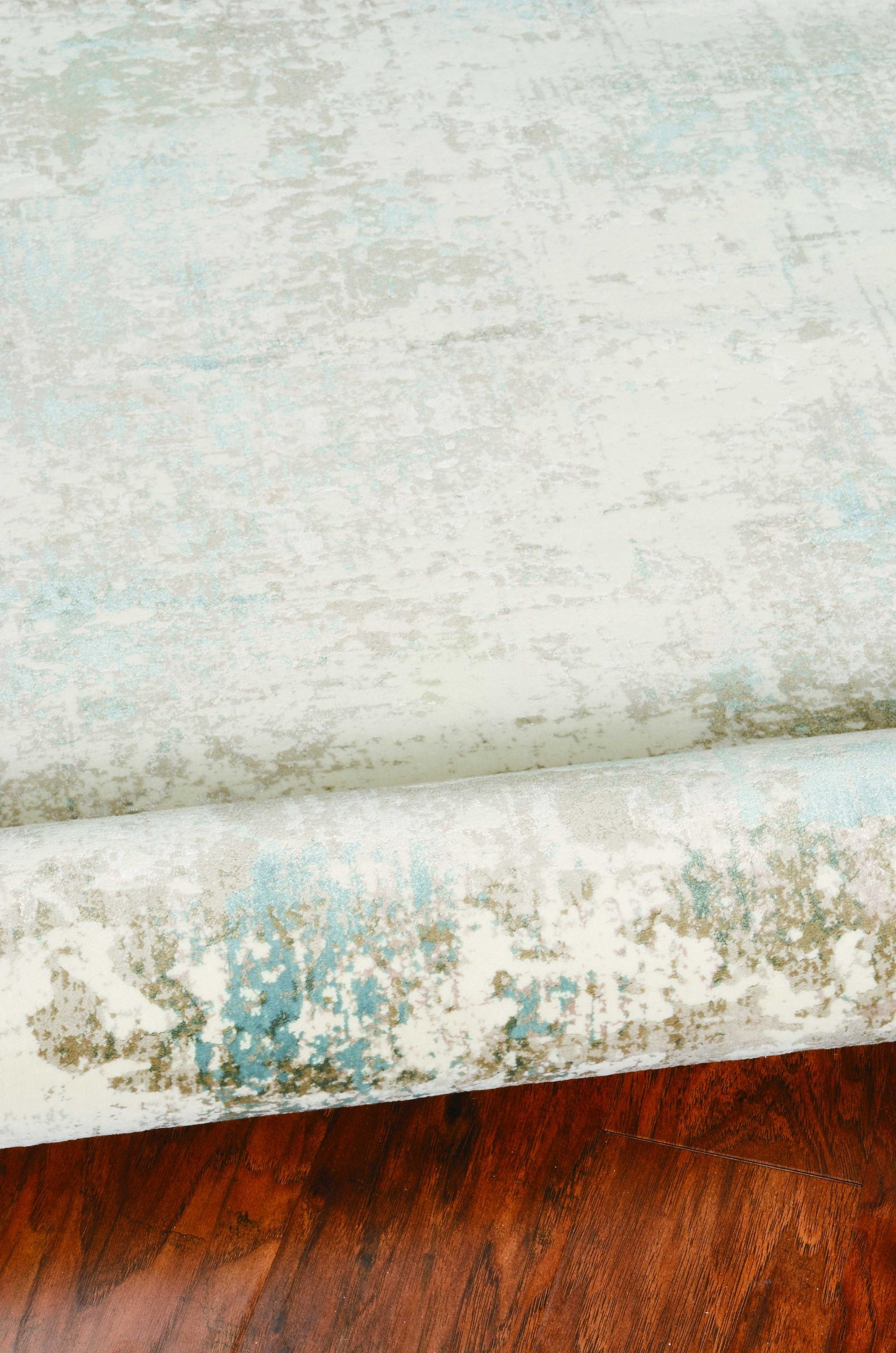 A beautiful 94" x 134" ivory rug made of polypropylene and viscose, featuring a modern hi/lo pattern with soft sheen highlights, perfect for elegant home decor.