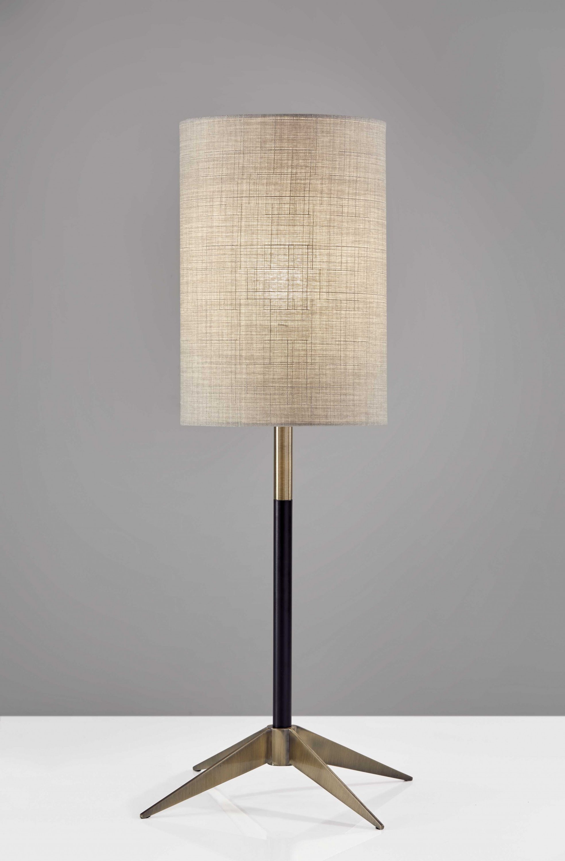 Antique Brass Metal Tripod Base Table Lamp with Matte Black Accent and Natural Fabric Shade, showcasing mid-century modern design.