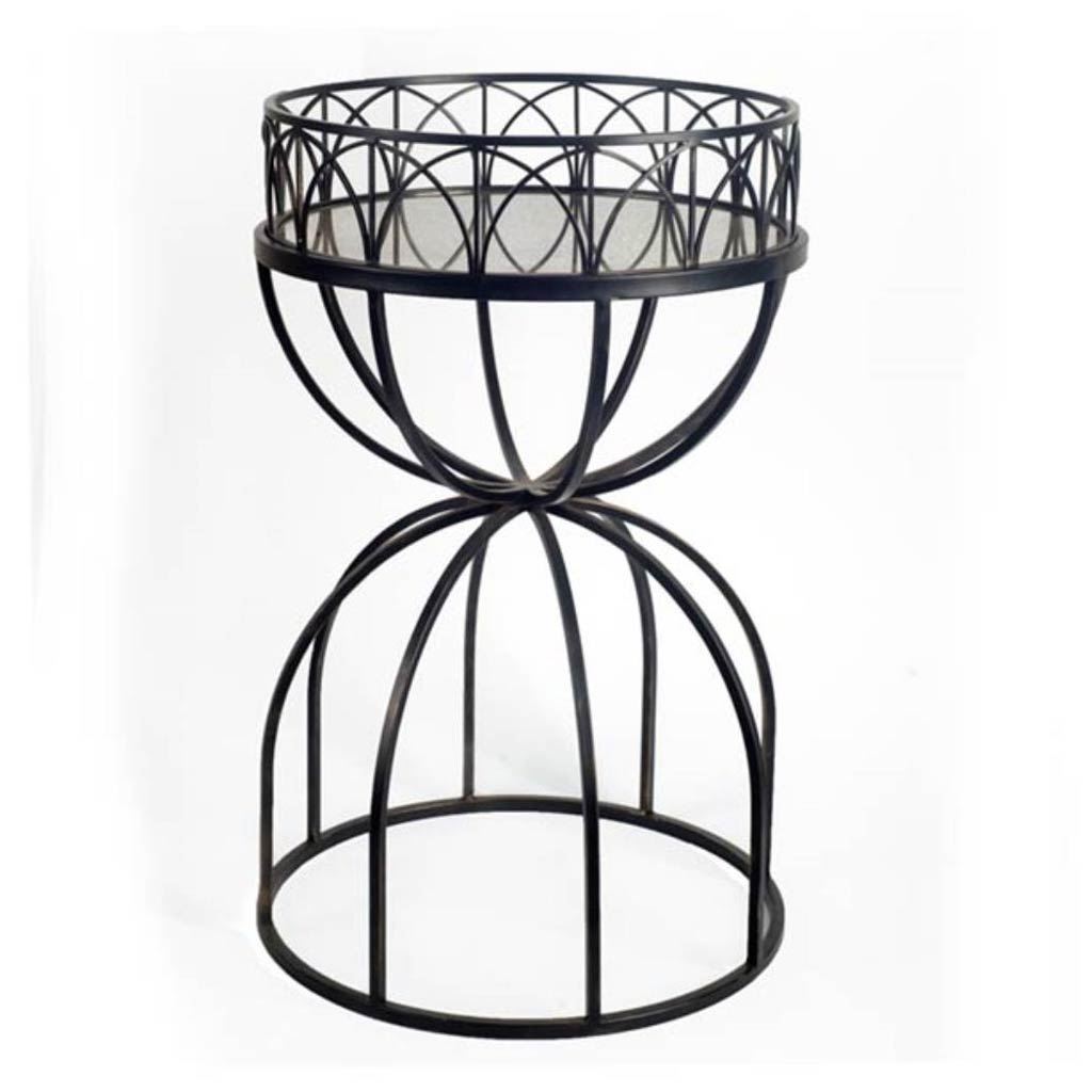Hour-glass shaped accent table with a mirrored top and black iron base, showcasing a modern and elegant design.
