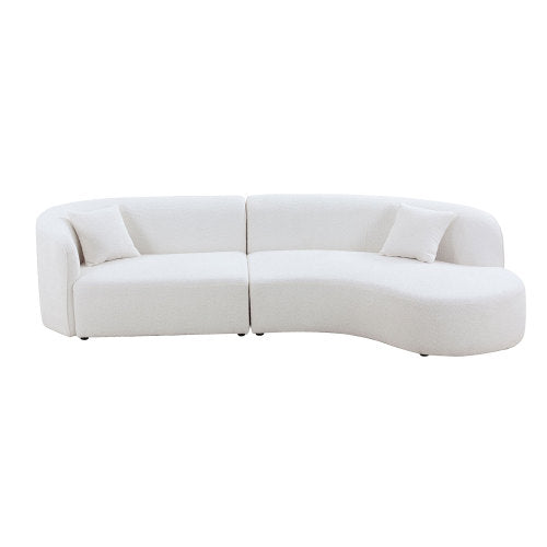Luxury modern curved sofa with chaise in a stylish living room setting, featuring soft boucle fabric and elegant design.