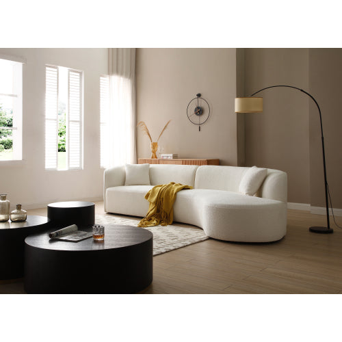 Luxury modern curved sofa with chaise in a stylish living room setting, featuring soft boucle fabric and elegant design.