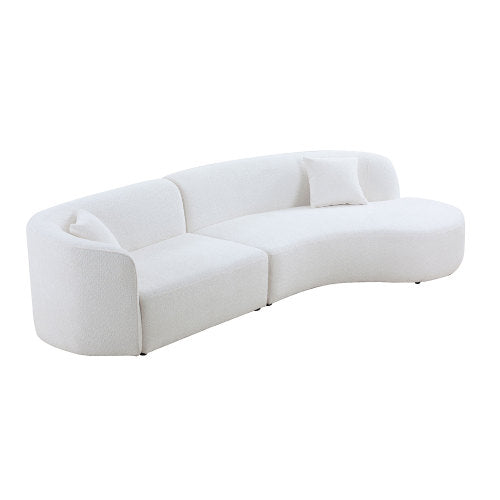 Luxury modern curved sofa with chaise in a stylish living room setting, featuring soft boucle fabric and elegant design.