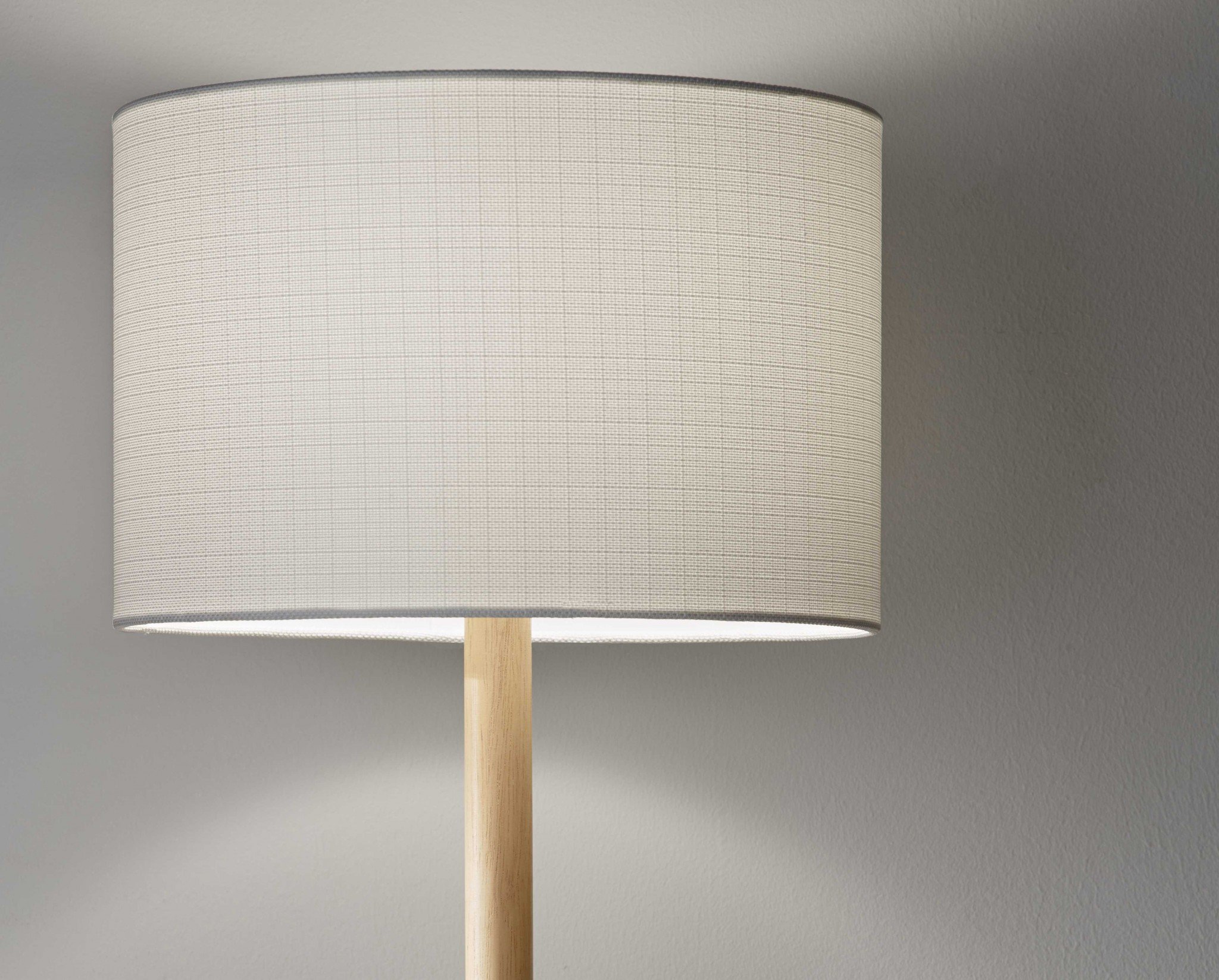 Natural wood floor lamp with a textured white fabric shade, showcasing a simple cabin style design.