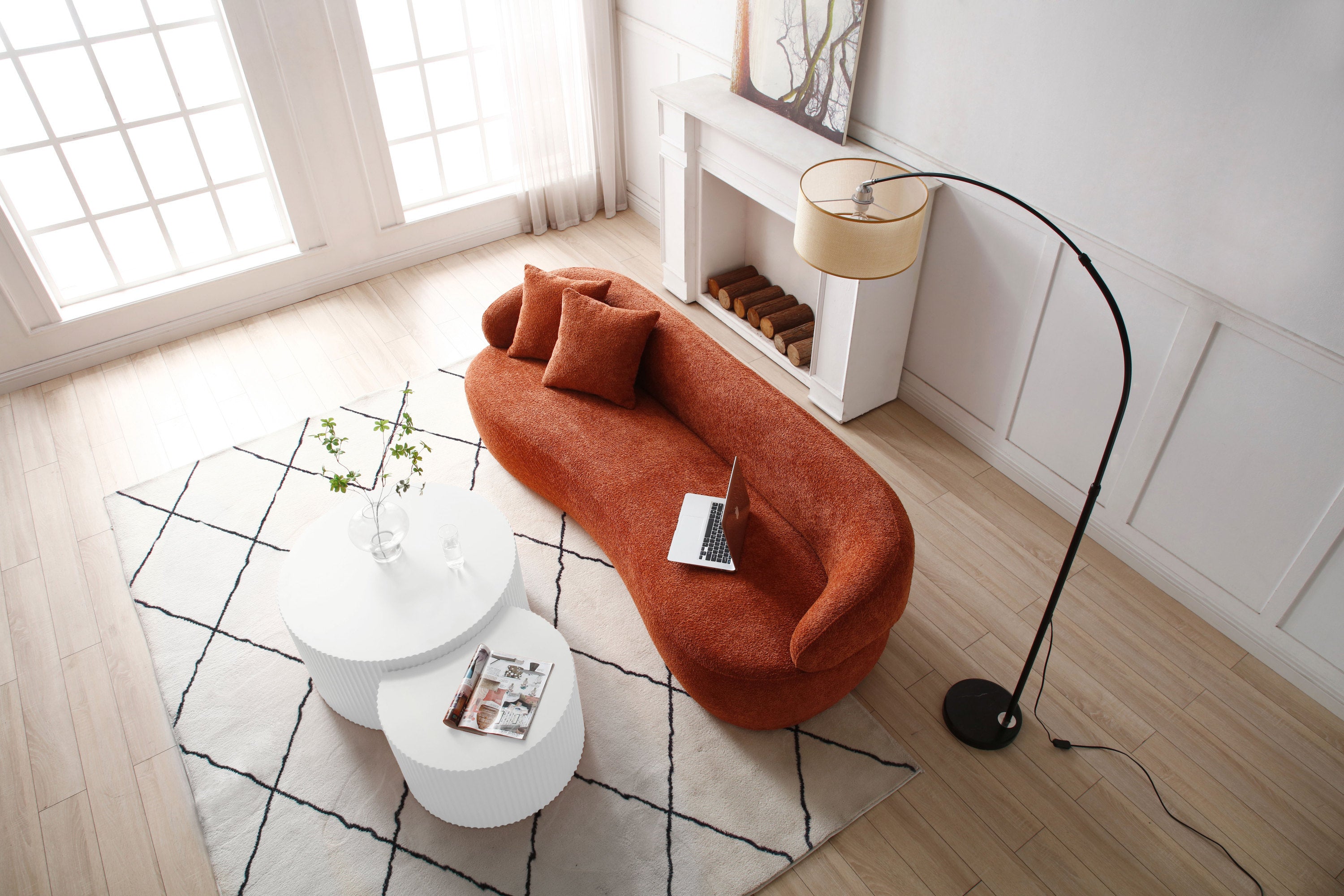 A stylish ORANGE Mid Century Modern Curved Sofa featuring a soft Boucle fabric, designed for comfort and elegance in a living room setting.