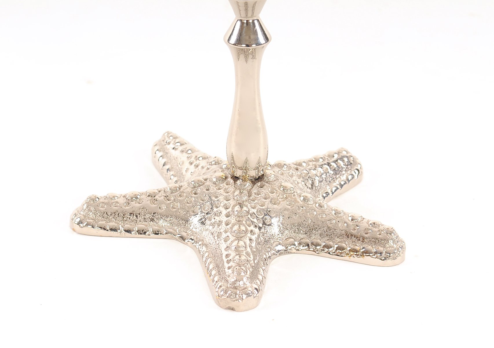 A beautiful silver finish starfish taper candle holder made of solid brass, showcasing a unique starfish design.