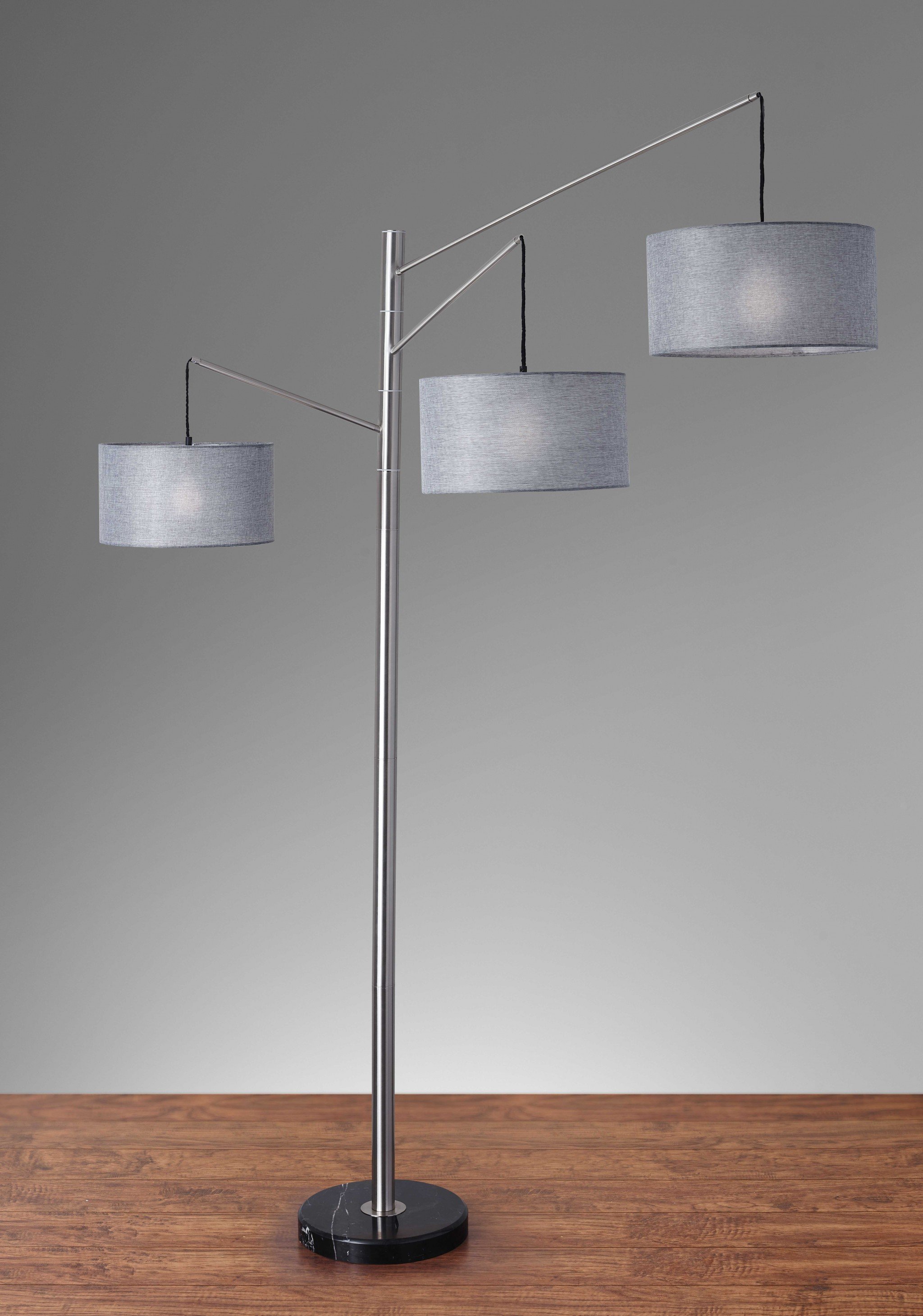 Three Light Floor Lamp with brushed metal swing arms and charcoal gray drum shades, featuring a black marble base.