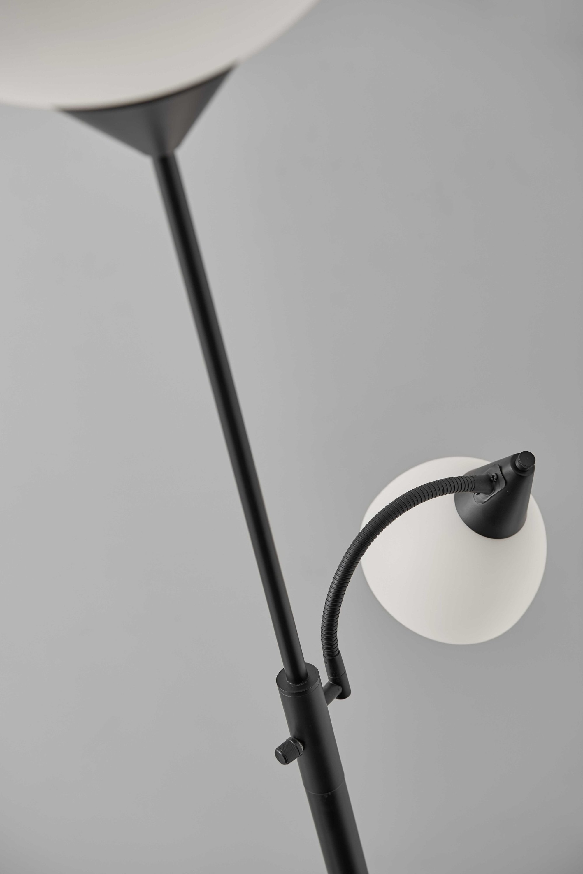 Torchiere Plus Chairside Floor Lamp featuring a black metal body and adjustable gooseneck reading light with white acrylic shades.