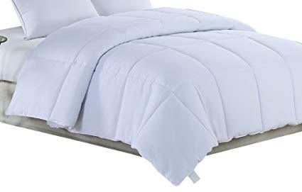 White Medium Weight Hypoallergenic Twin Down Alternative Comforter displayed on a bed, showcasing its soft texture and neutral color.