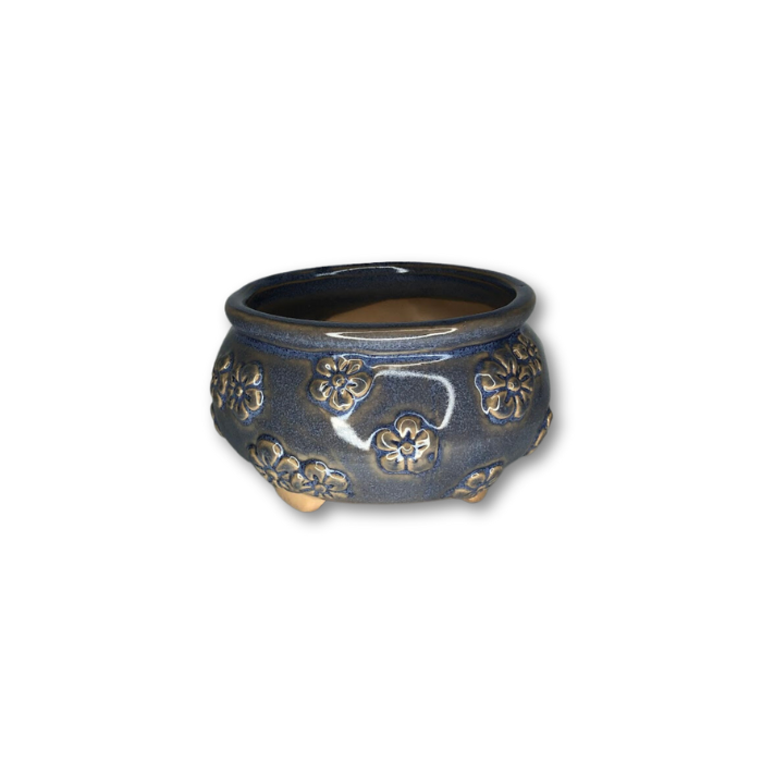 A decorative blue glazed pot featuring a raised flower pattern, perfect for indoor and outdoor plants.