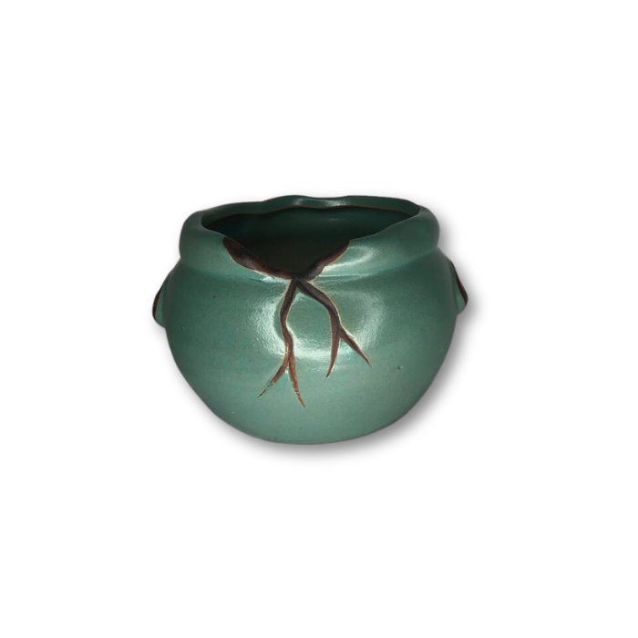 A green ceramic pot featuring a unique cracked rim design, perfect for small plants and home decor.