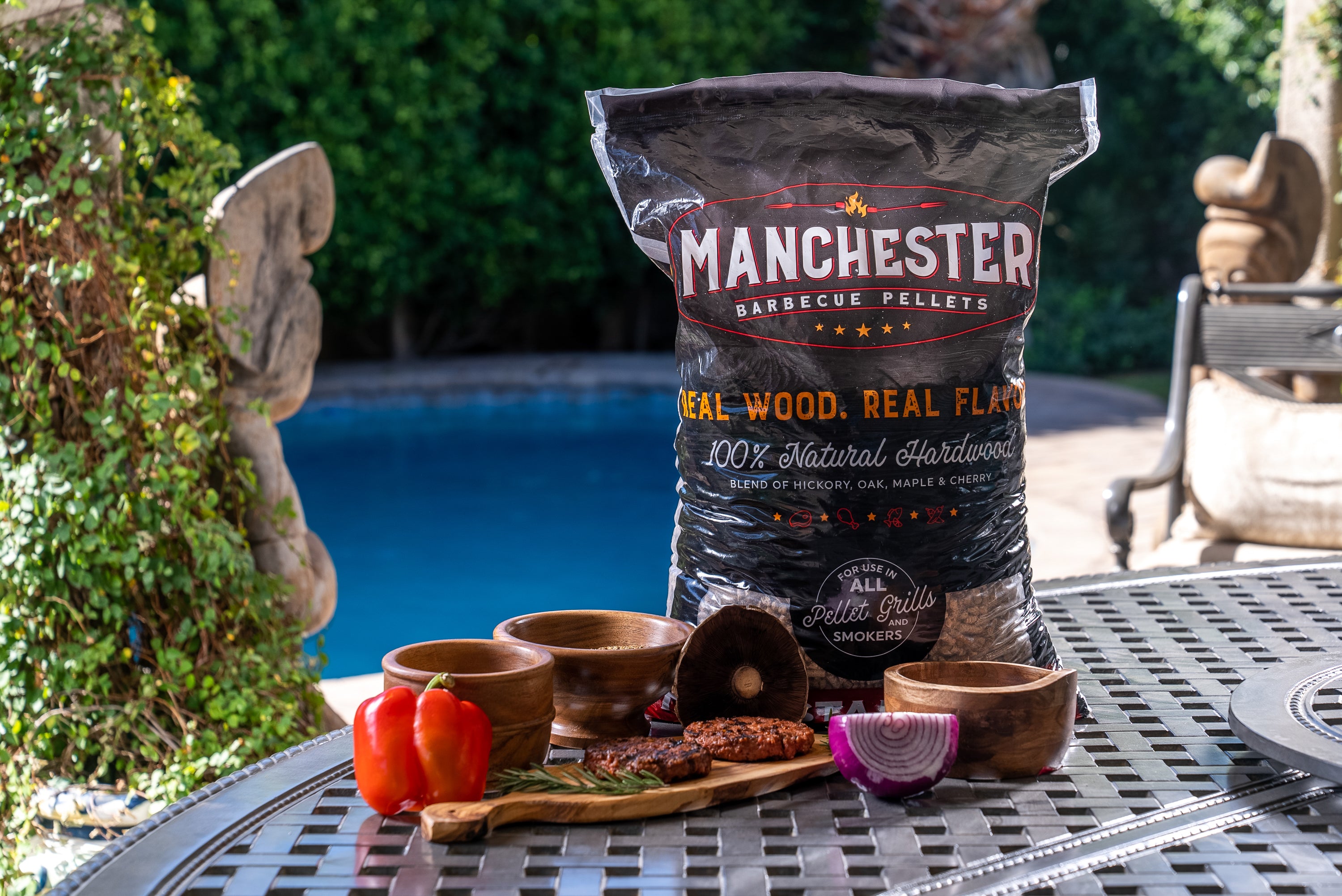 A 20lb bag of Manchester Barbecue Pellets featuring a blend of Hickory, Oak, Maple, and Cherry wood, ideal for grilling and smoking.