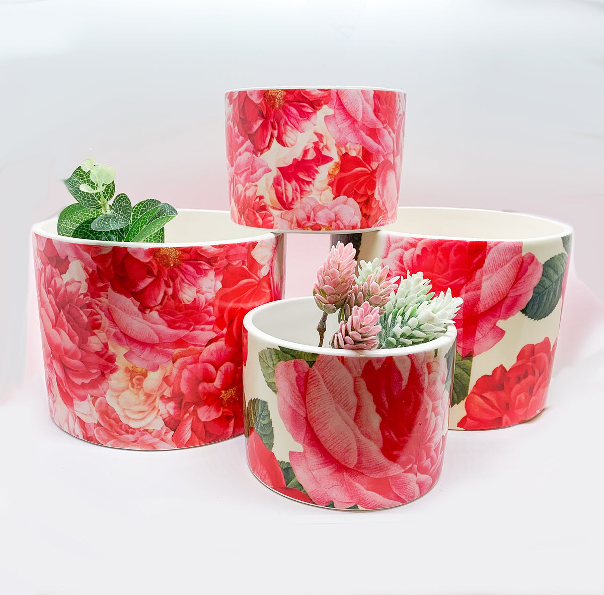 Two stunning Rose Marie floral cachepots in pink and red ceramic, showcasing intricate rose patterns.