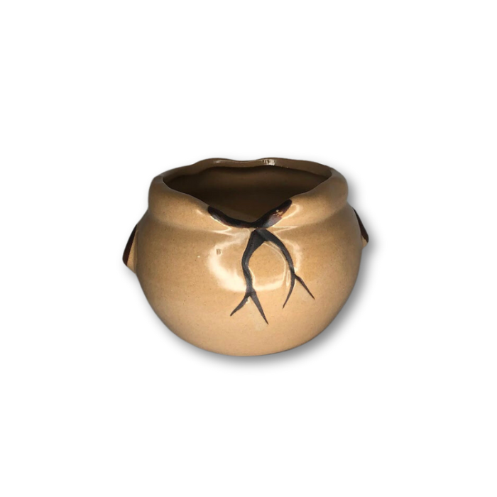 Tan ceramic pot featuring a unique cracked rim design, perfect for indoor plants and home decor.