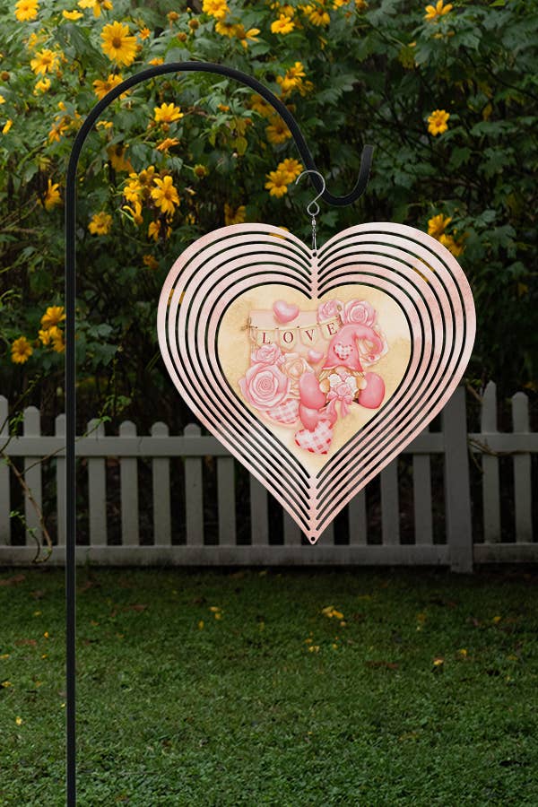 A vibrant pink heart-shaped wind spinner featuring a love gnome, perfect for Valentine's Day garden decor.