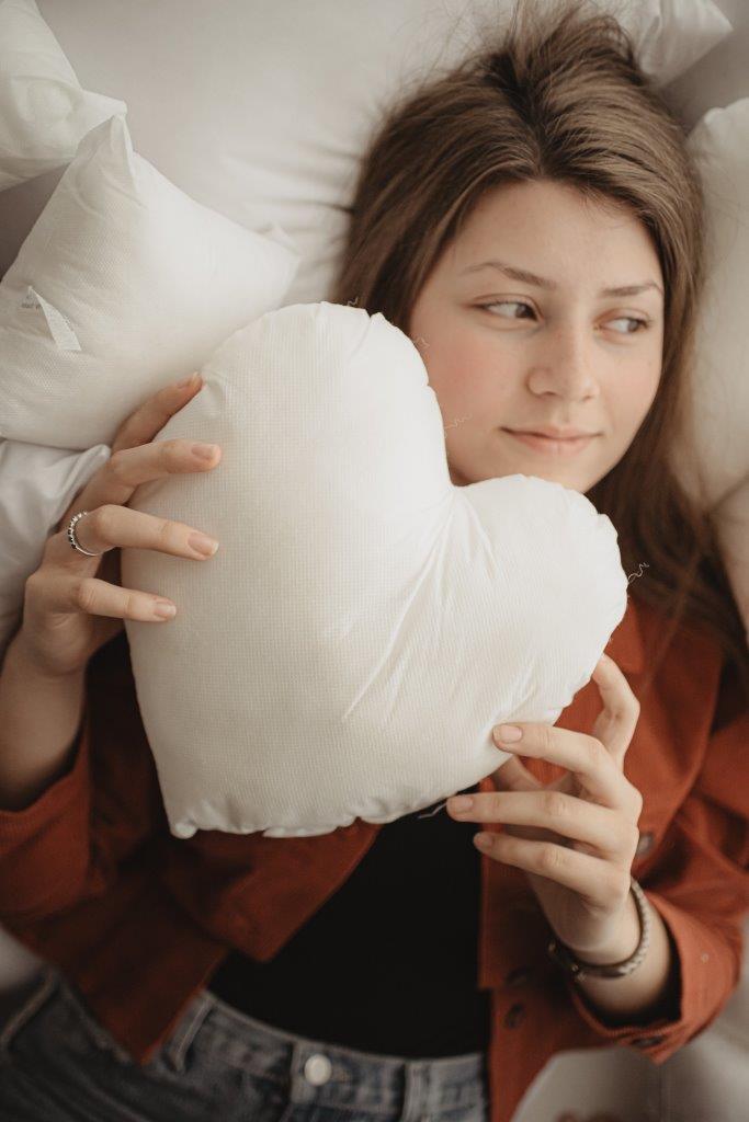 A collection of heart-shaped hypoallergenic polyester filled inserts in various sizes, showcasing their soft texture and vibrant colors.