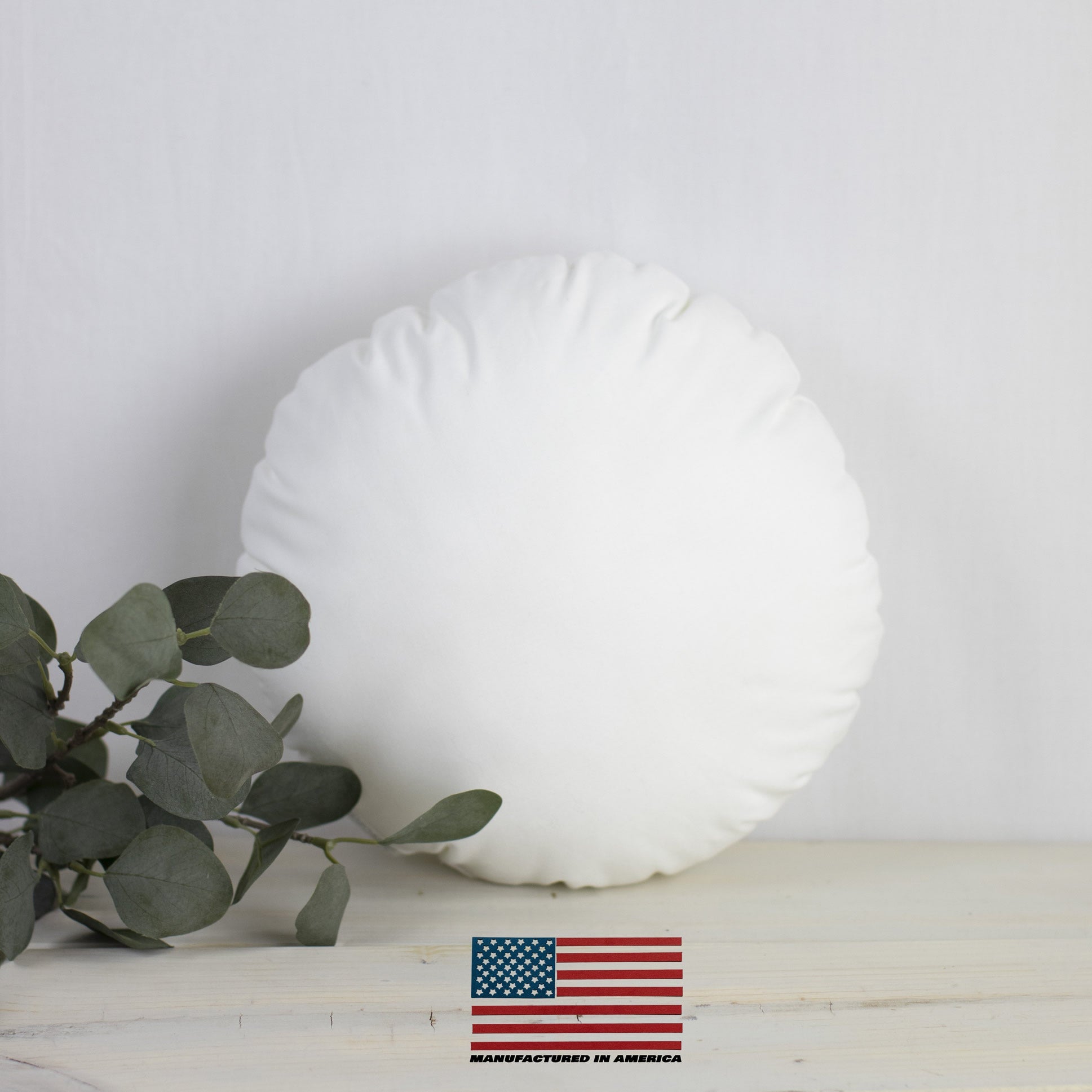 A 32-inch round pillow insert made of hypoallergenic polyester fiberfill, featuring a durable woven cotton blend outer shell, ideal for indoor and outdoor use.