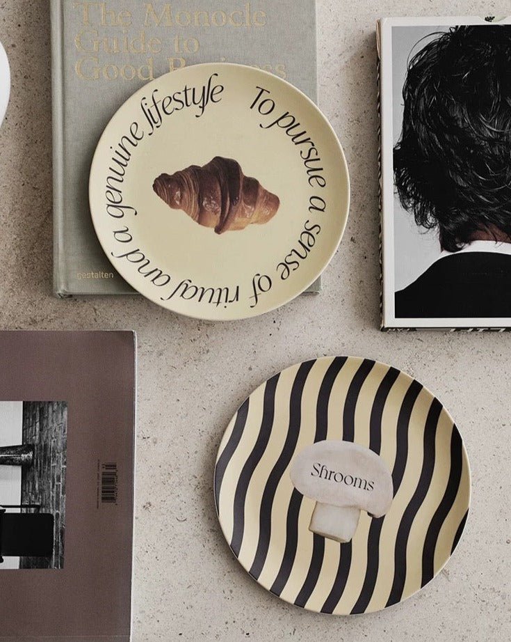 A set of four modern bamboo fiber plates featuring mushroom and croissant prints, showcasing eco-friendly design and vibrant colors.