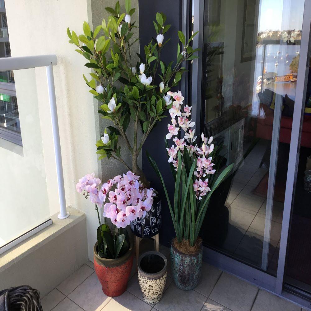 A beautiful 66cm Multi Stem Pink Butterfly Artificial Potted Orchid in a sleek white ceramic pot, showcasing vibrant pink blooms and realistic silk petals.