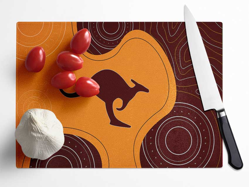 Aboriginal Kangaroo 3 chopping board made of tempered glass with chinchilla ripple effect and anti-slip feet.