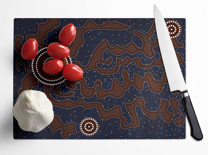 Aboriginal Pattern 3 chopping board made of tempered glass with a chinchilla ripple effect and anti-slip feet.