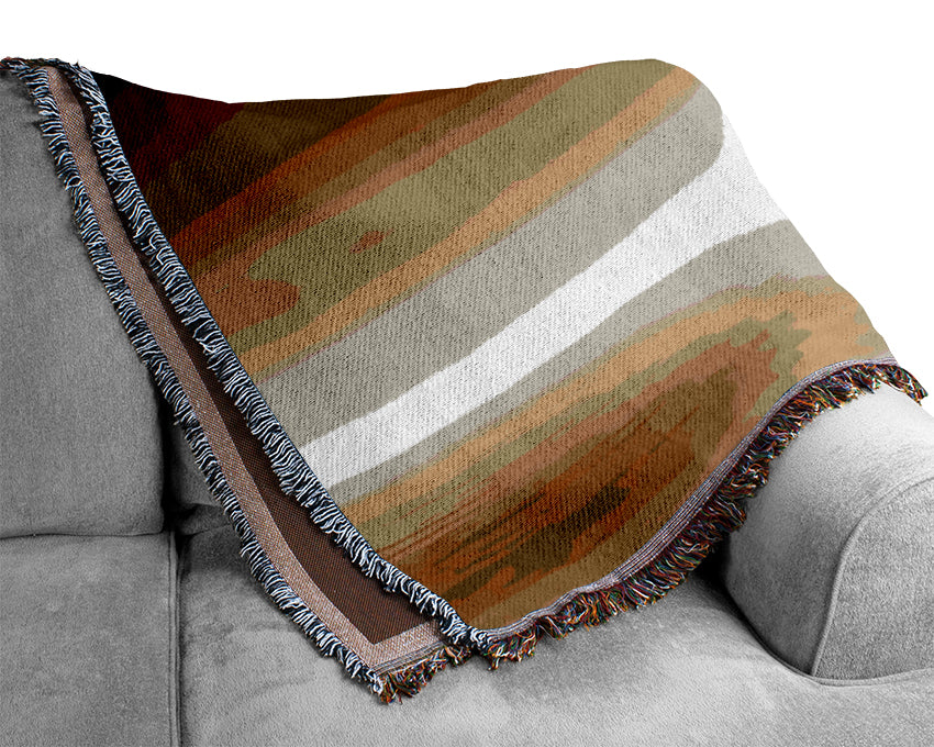 A luxurious Abstract Sun Beige throw blanket made from 100% cotton, featuring a thermal weave for breathability, draped elegantly over a couch.